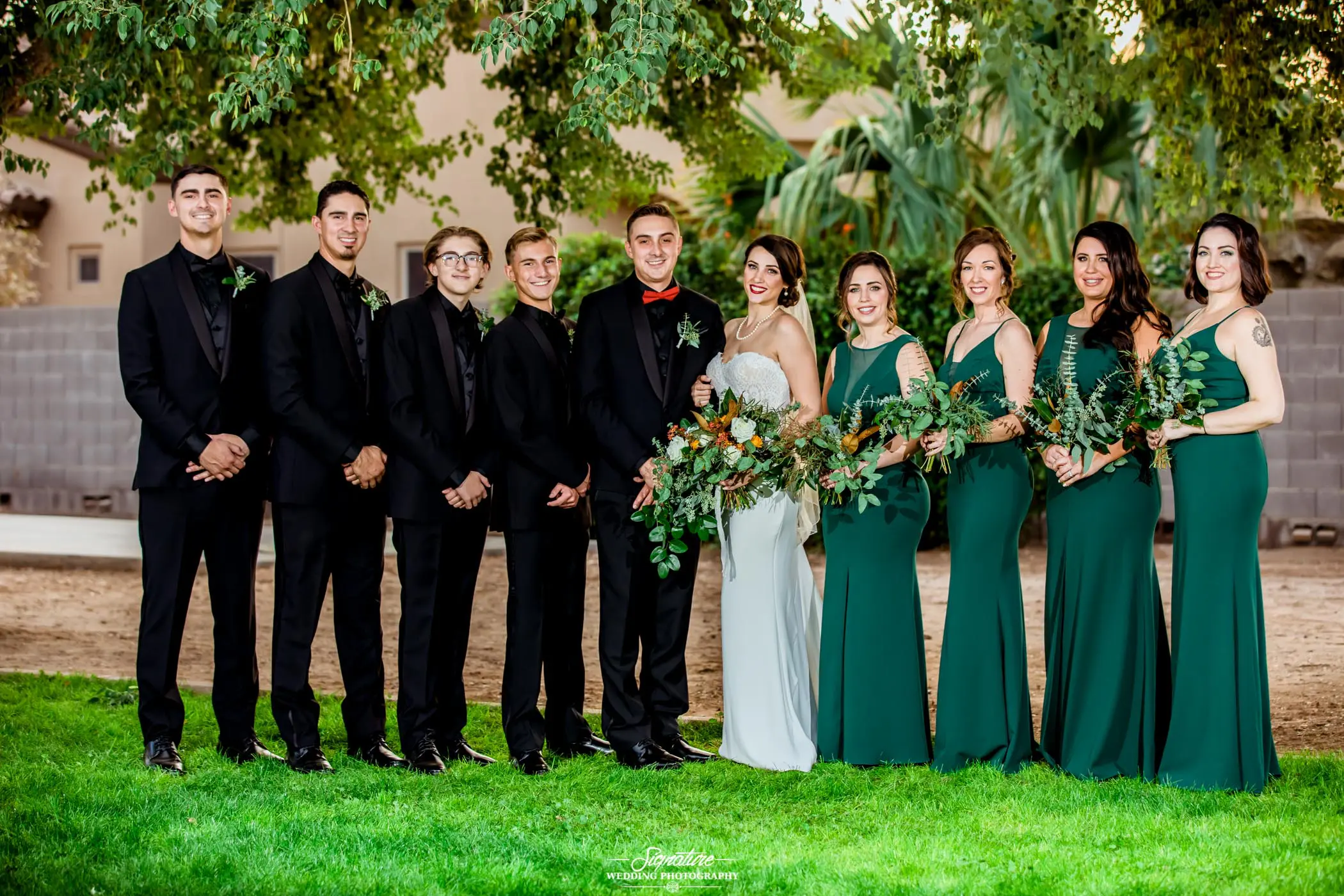 Wedding party smiling at camera outside