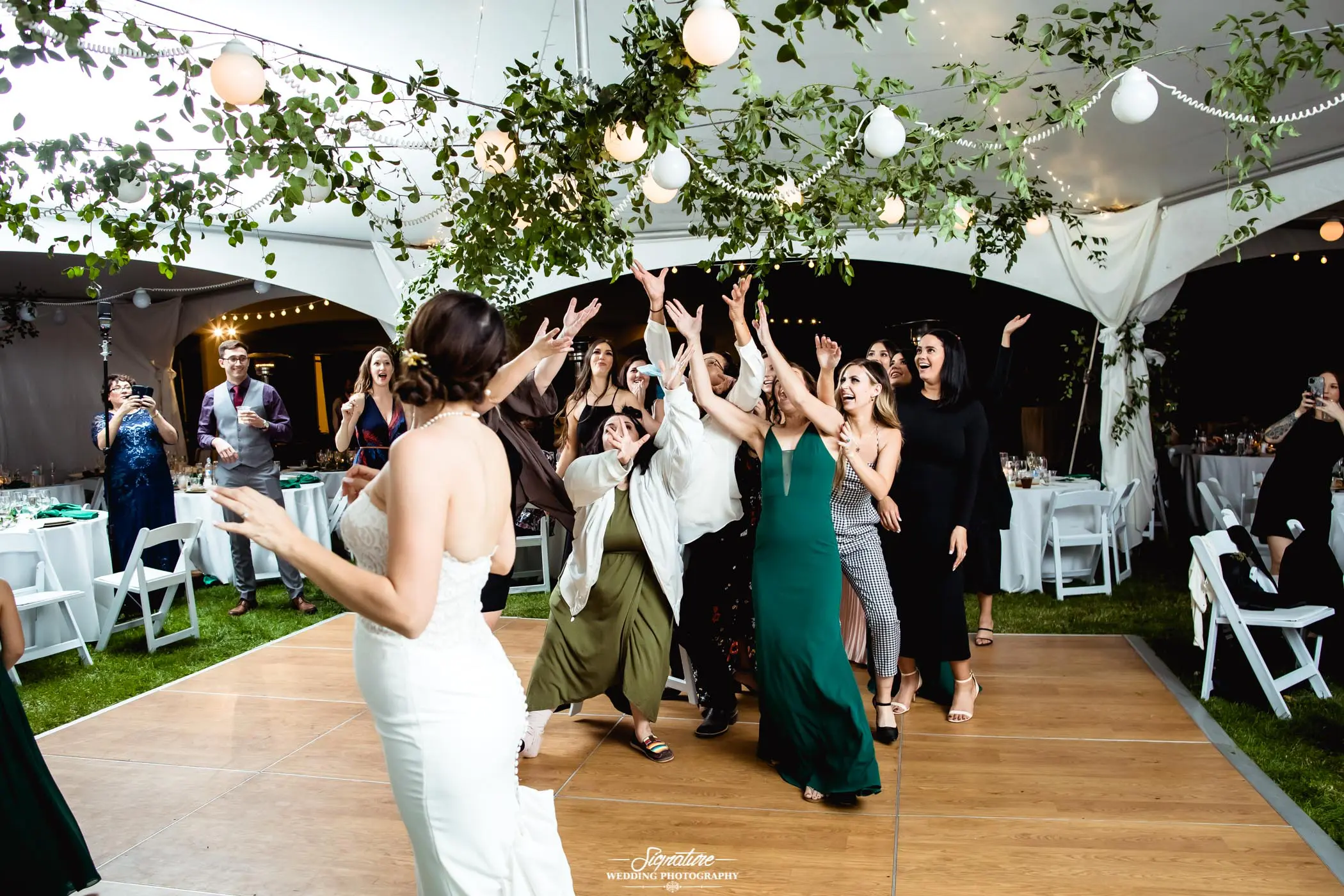 Bride with wedding guests for bouquet toss