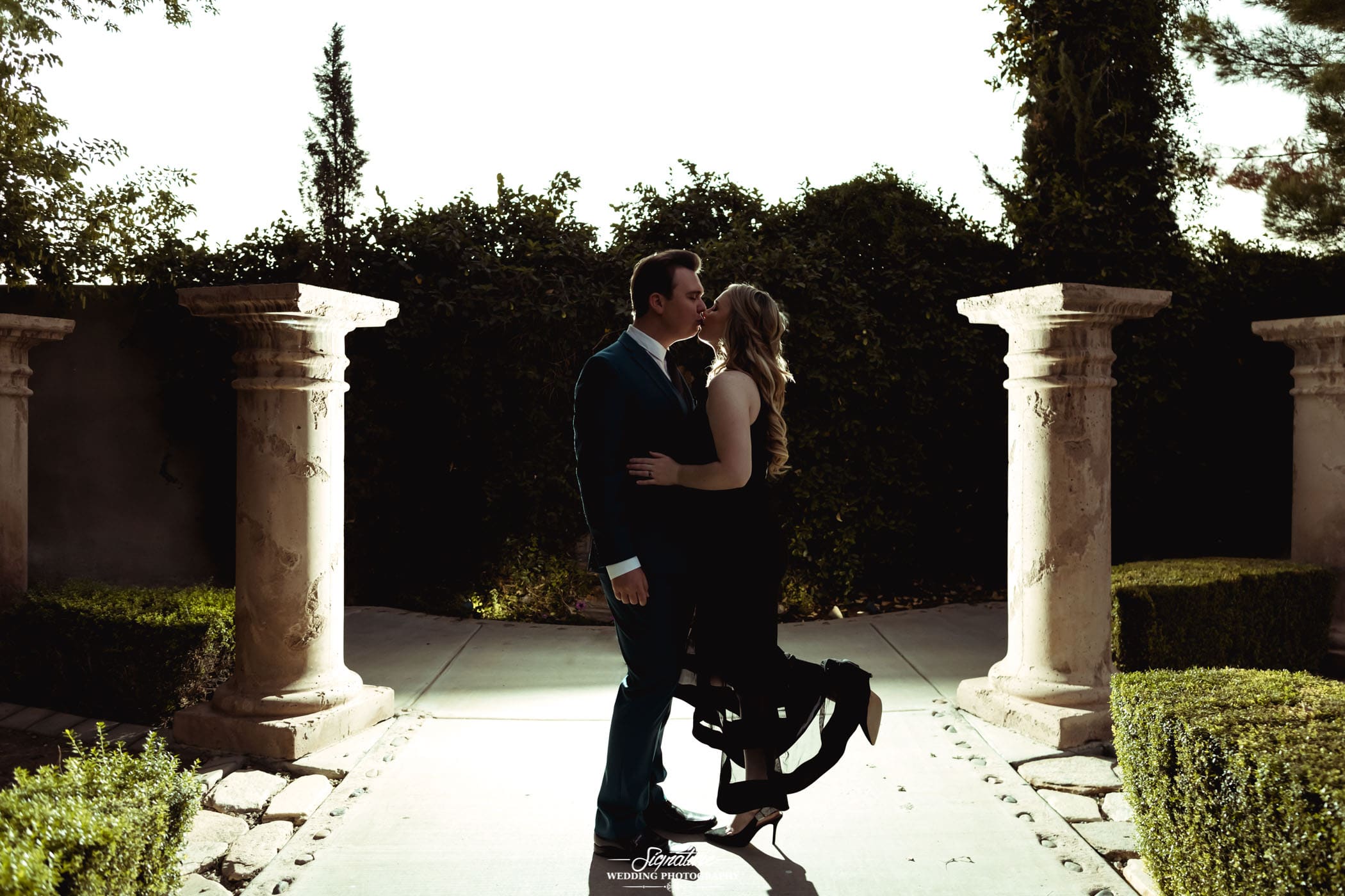 Couple kissing outside with pillars