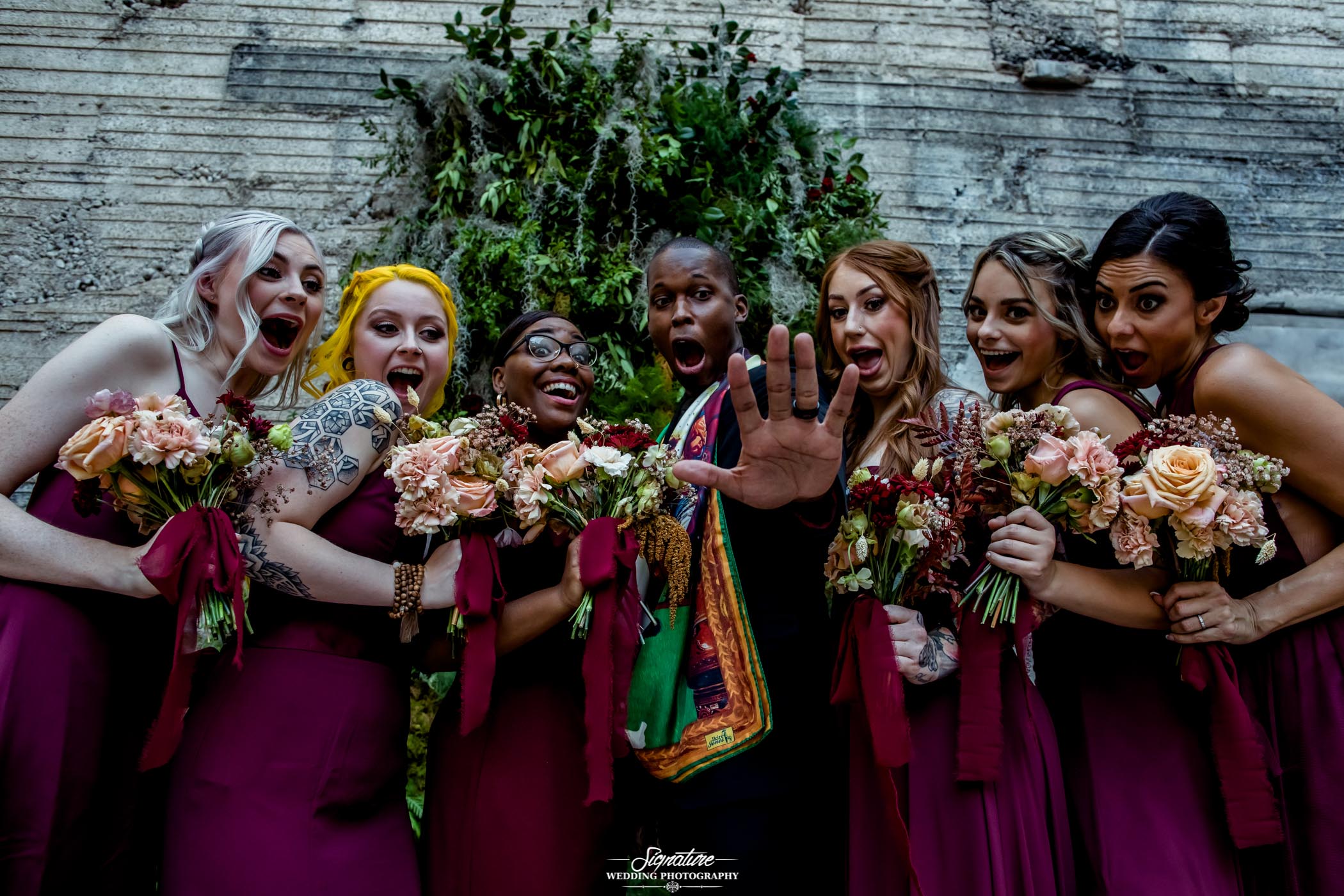 Groom with bridesmaids looking at wedding ring
