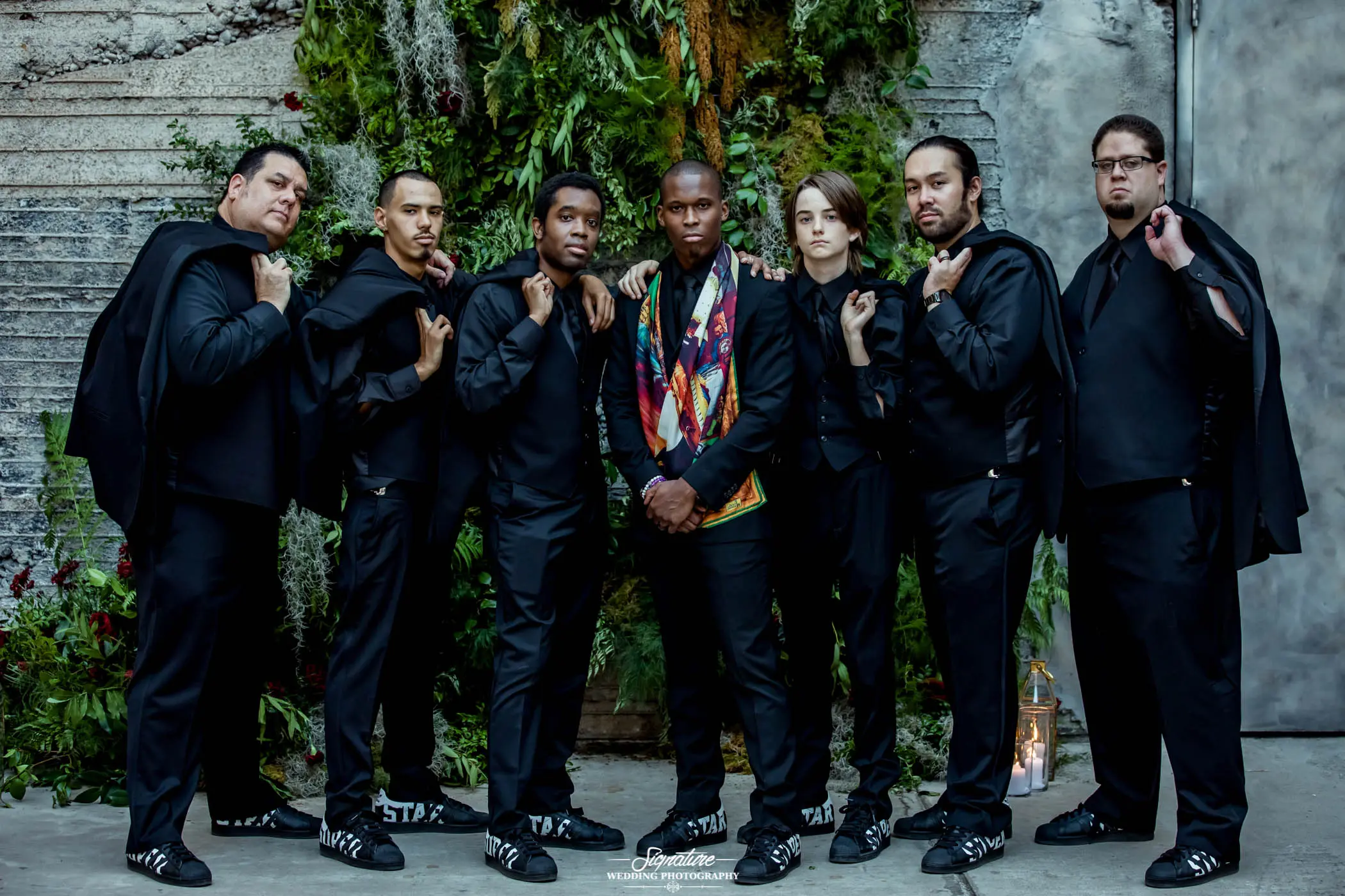 Groom with groomsmen holding jackets over shoulder