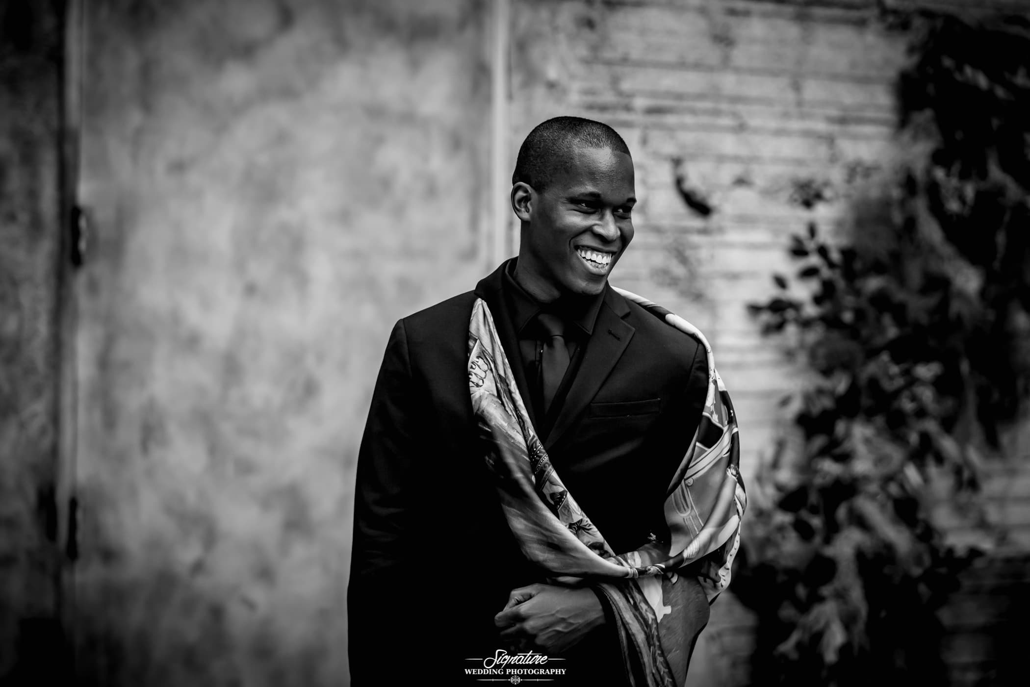 Groom smiling looking off camera black and white