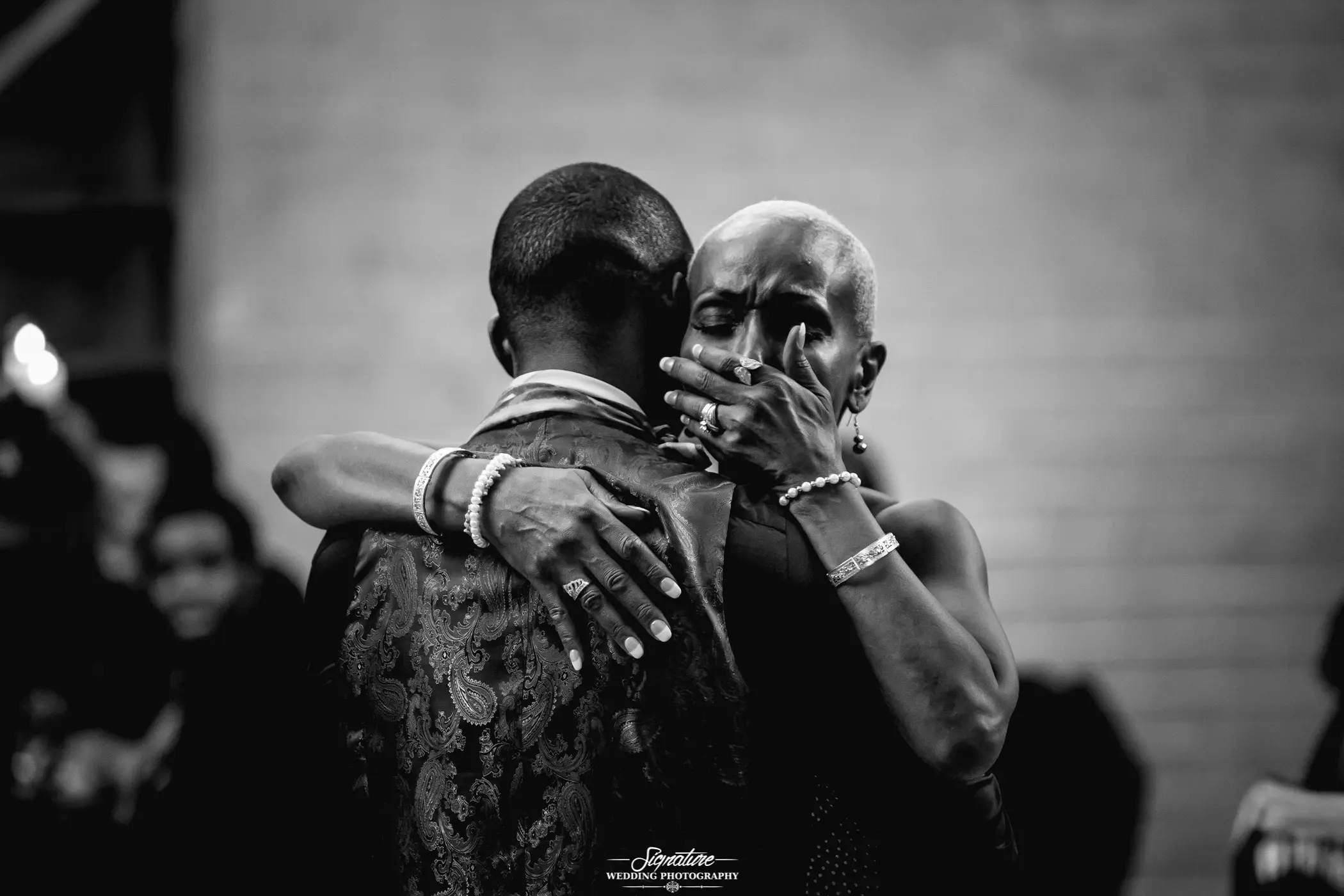 Mother with hand over mouth during mother son dance black and white