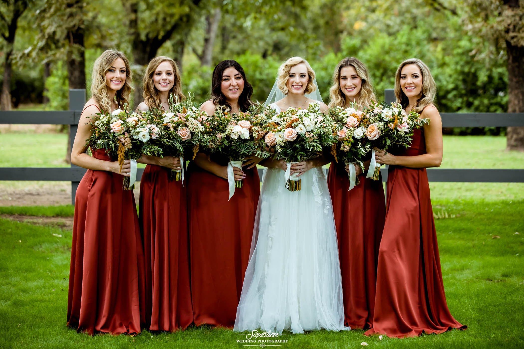 Bride and bridesmaids with bouquets smiling