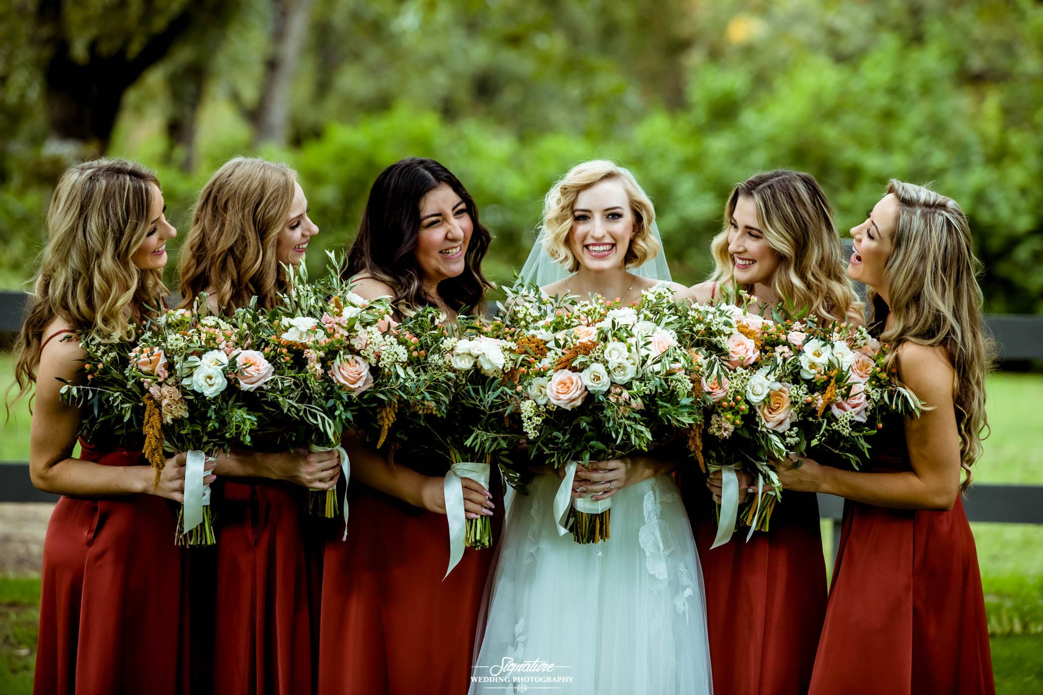 Bride with bridesmaids smiling at each other