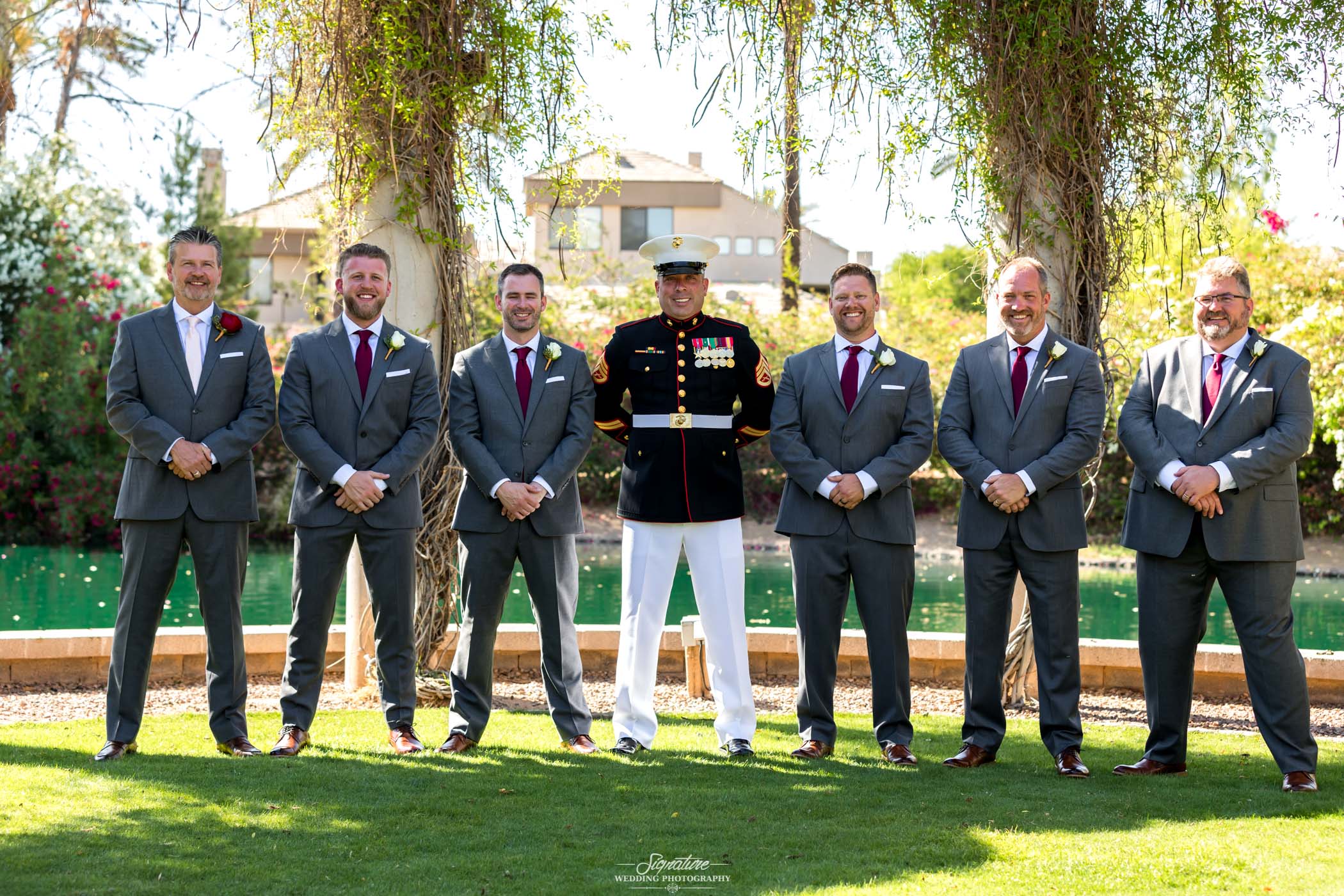 Groom in uniform with groomsmen posed outside