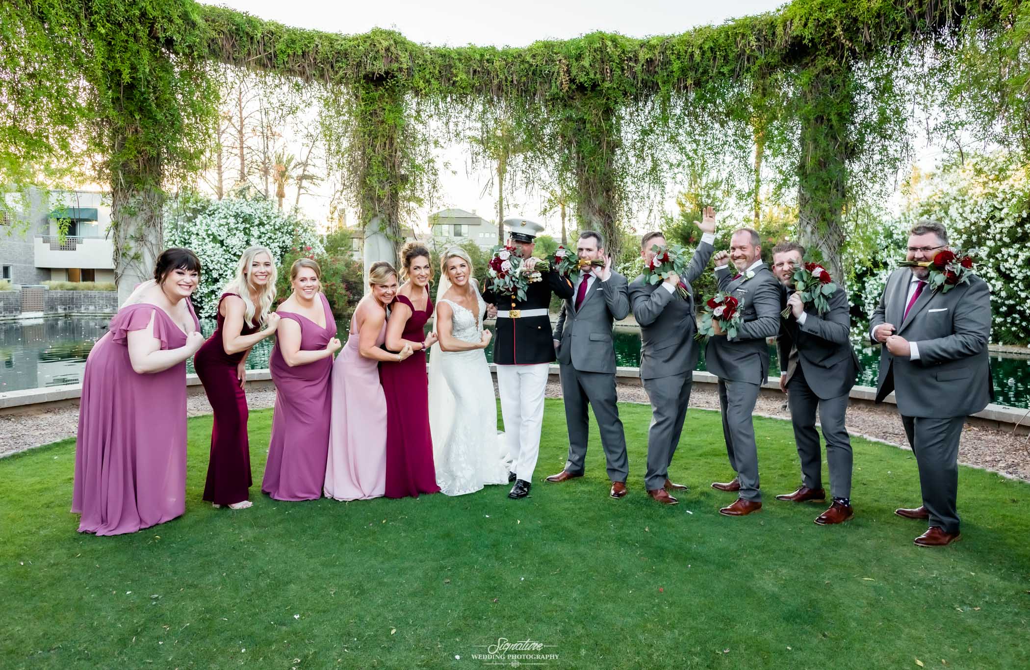 Wedding party funny pose outside under vines