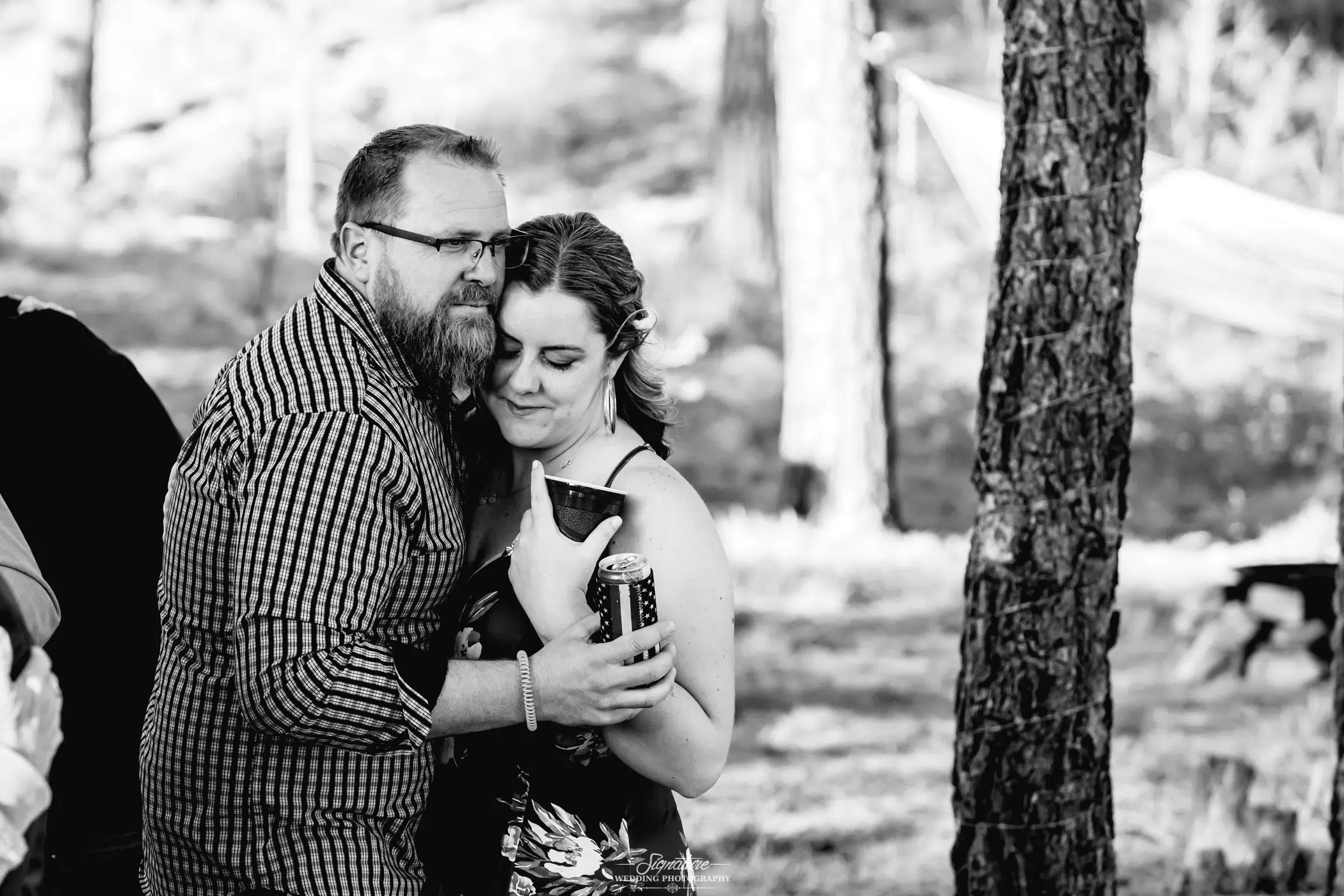 Wedding guests dancing with drinks in hand black and white