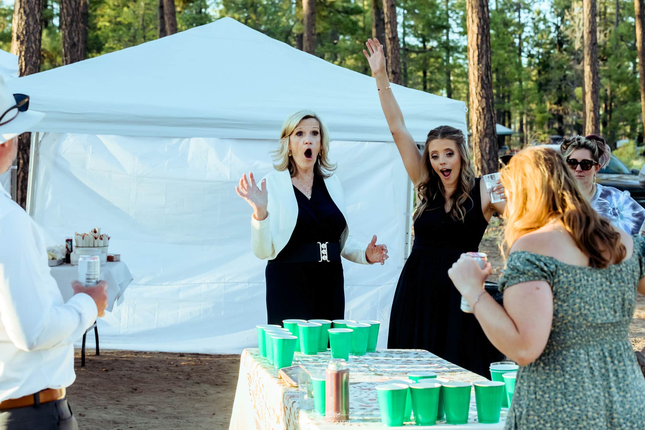 Wedding guests playing beer pong game outside