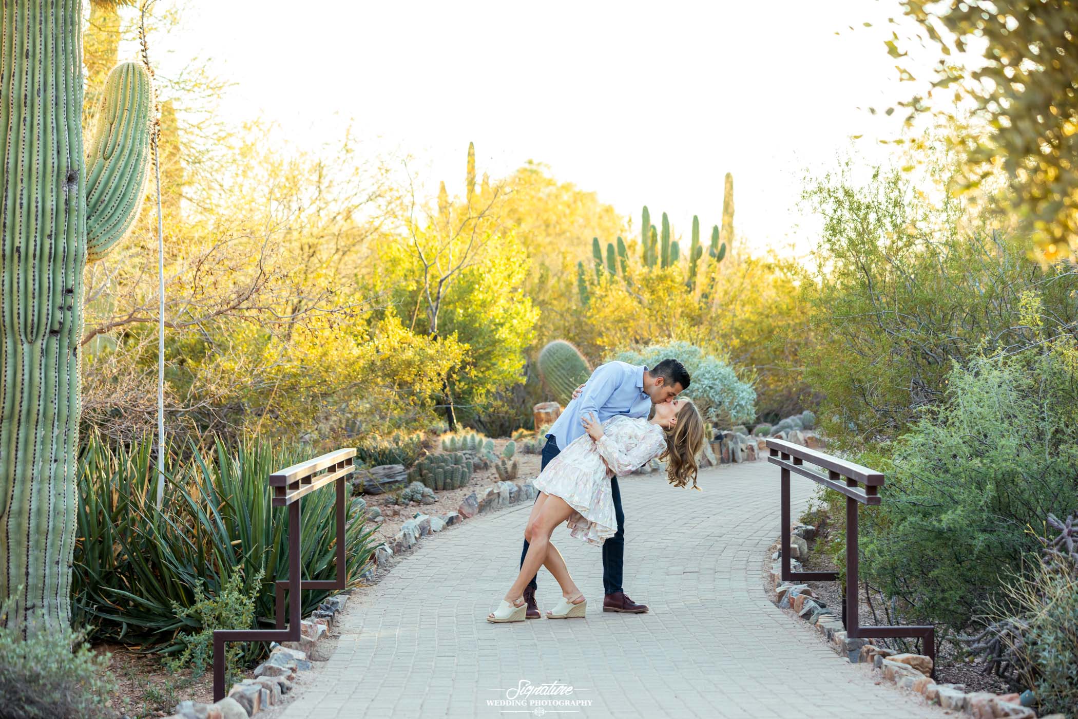 Couple kissing and dipping outside with desert plants