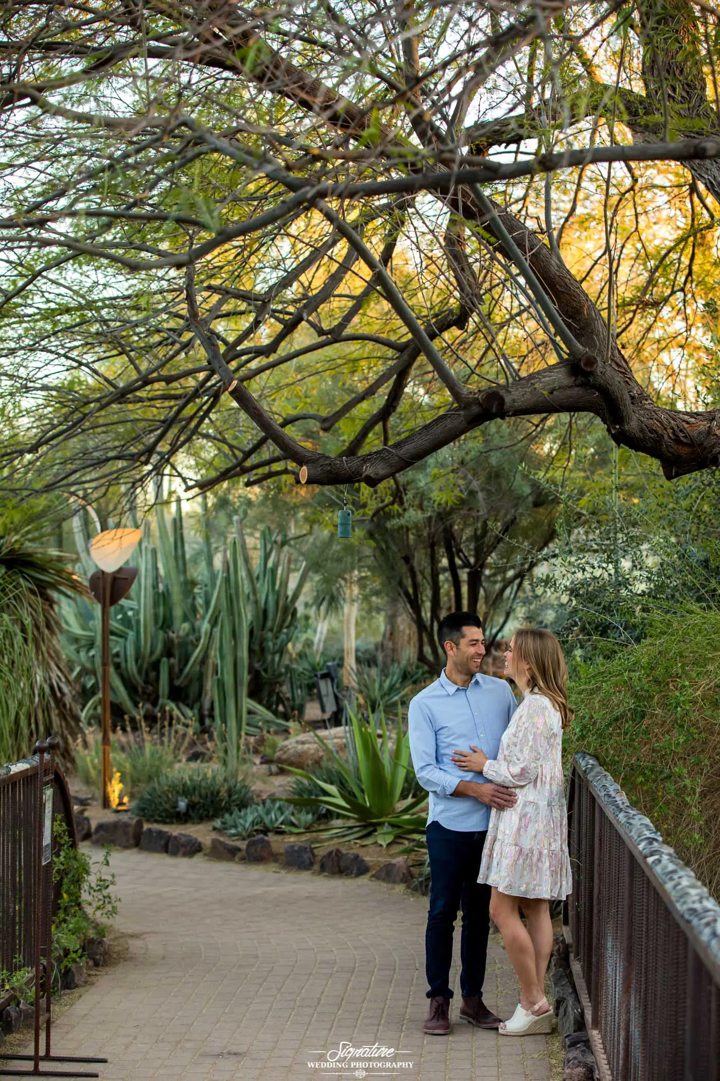 Couple smiling at each other under tree