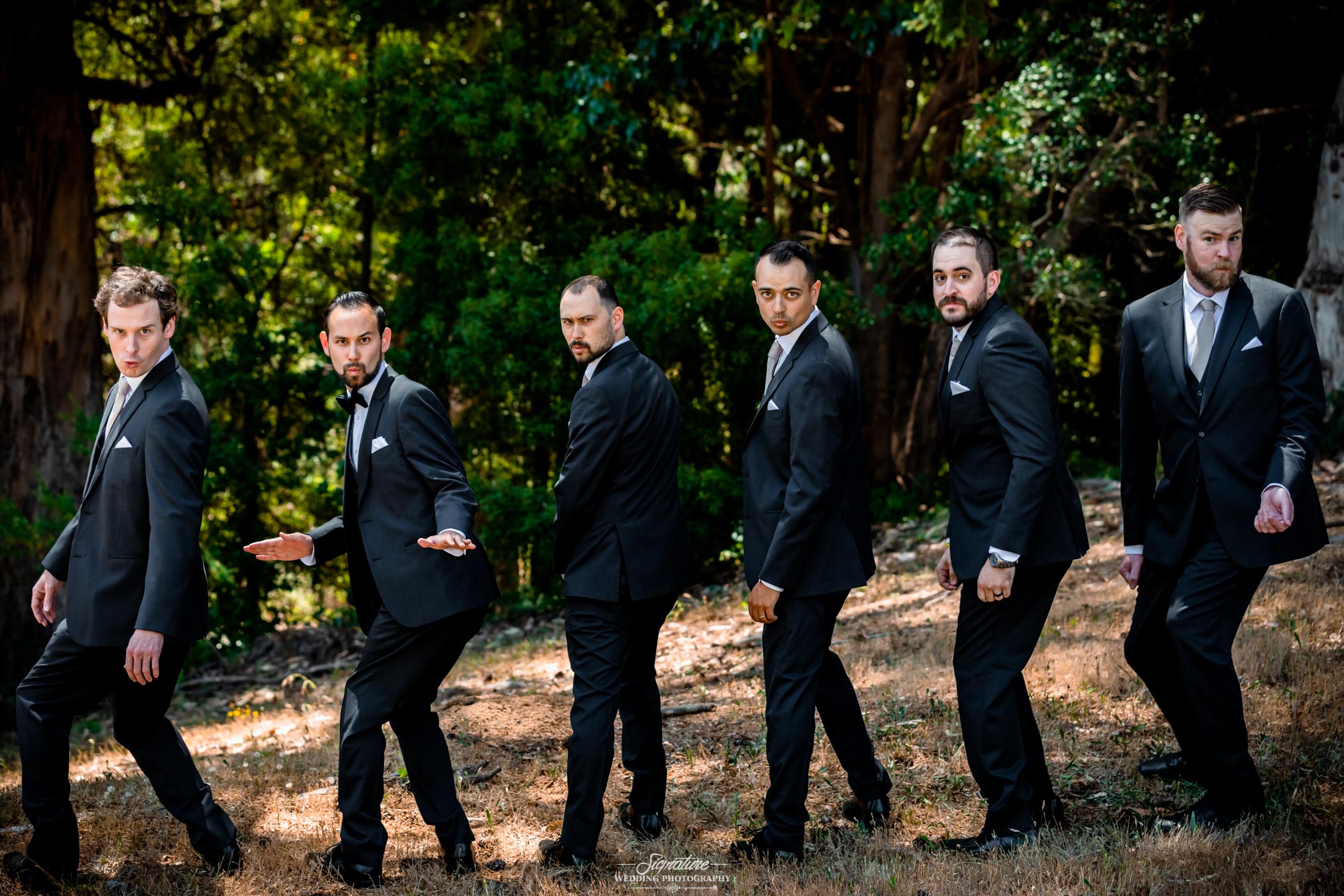 Groom and groomsmen fun pose in forest
