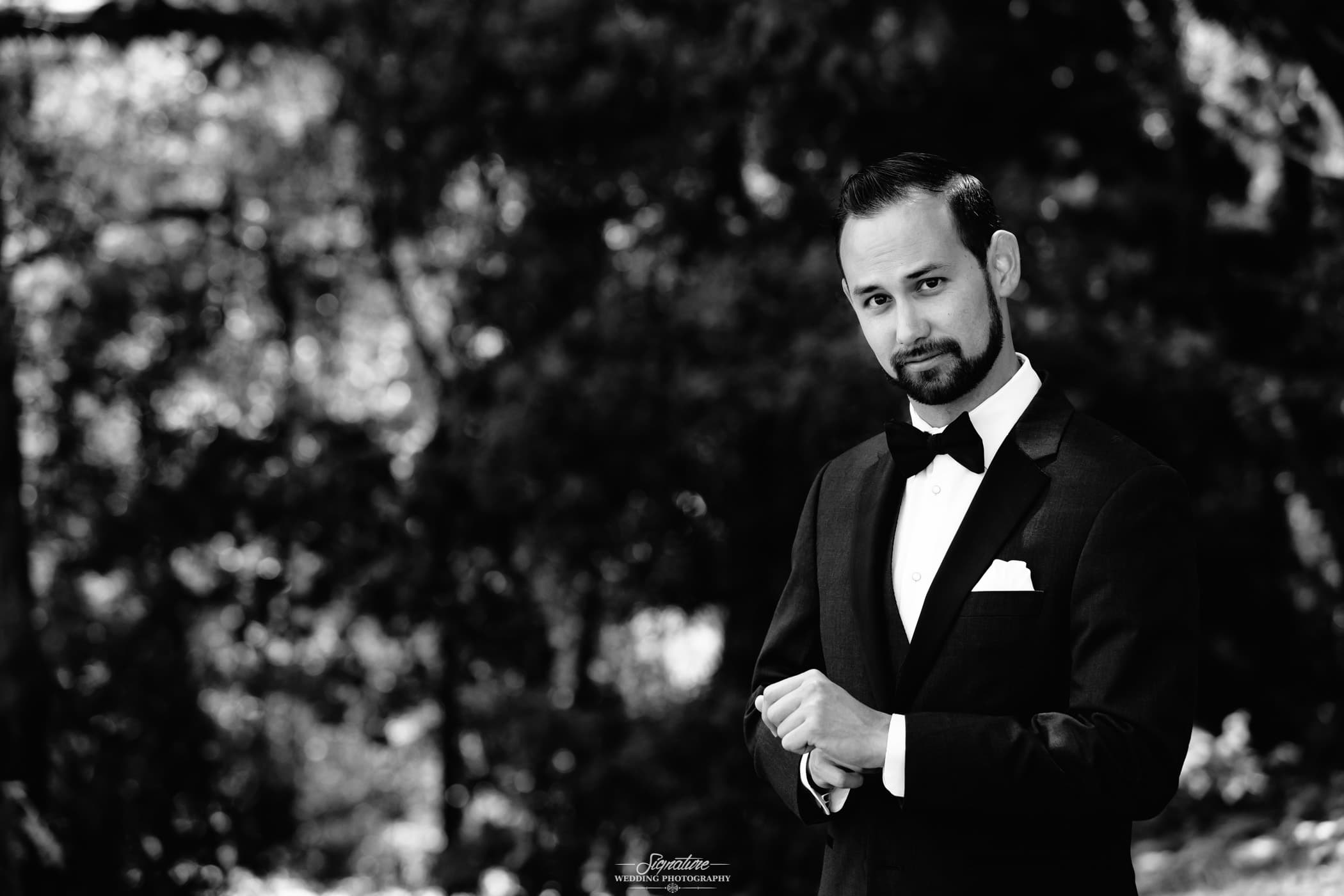 Groom looking at camera outside black and white