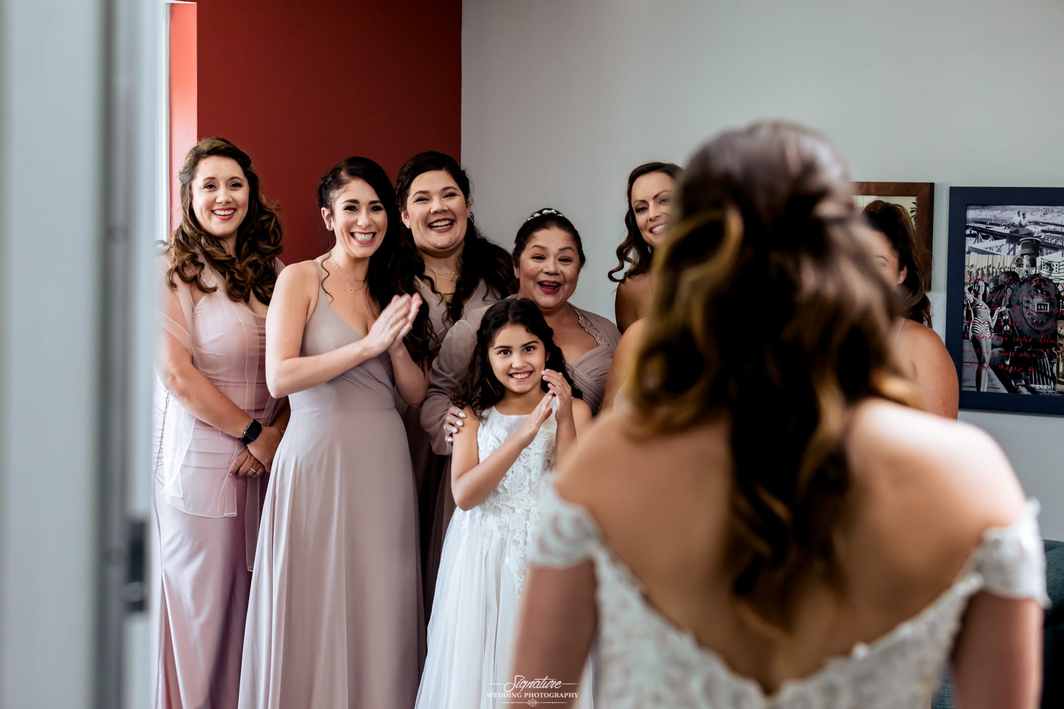 Bridal party reacting to bride in dress