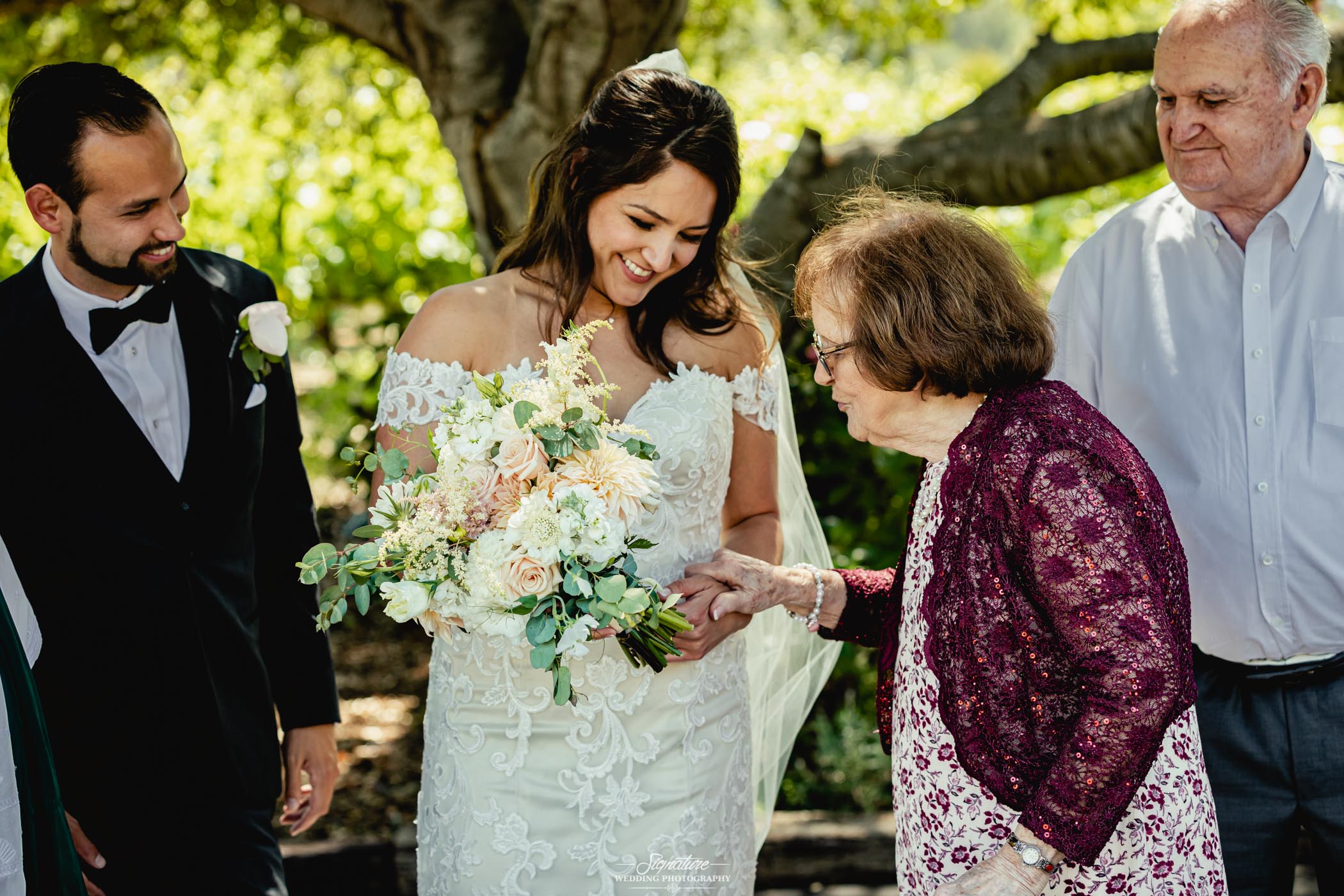 Matriarch holding brides arm outside candid