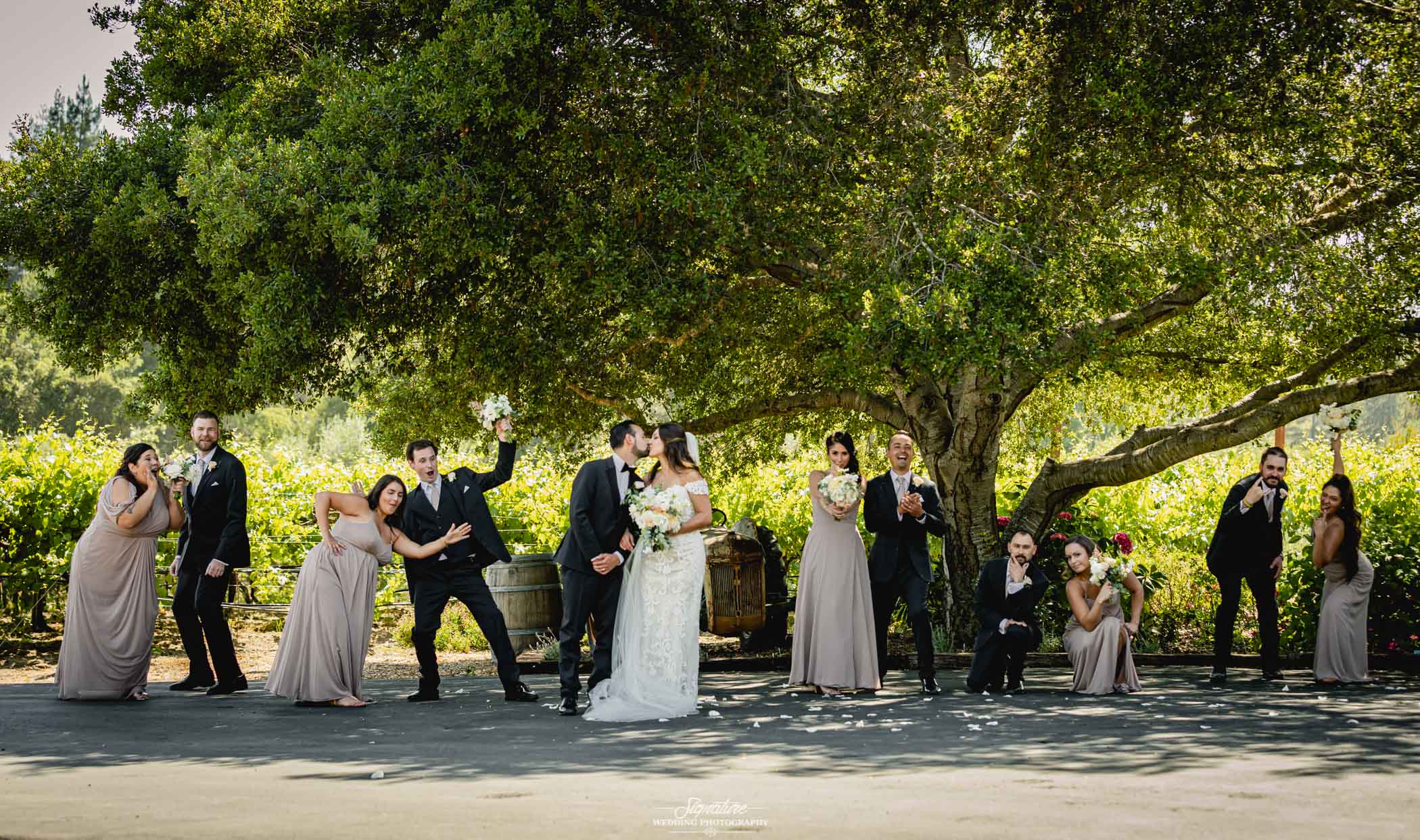 Wedding party funny poses outside under tree