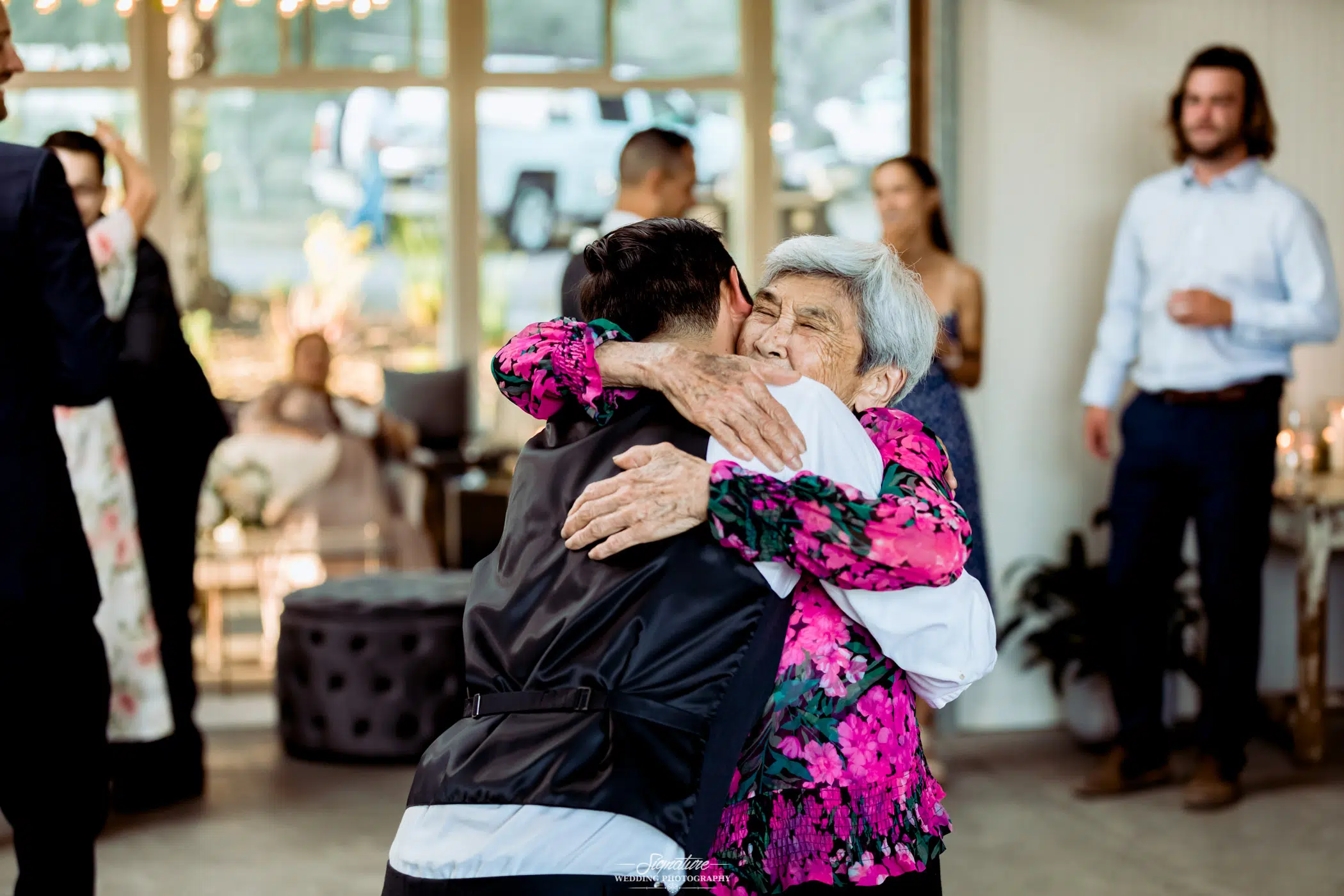 Groom hugging matriarch