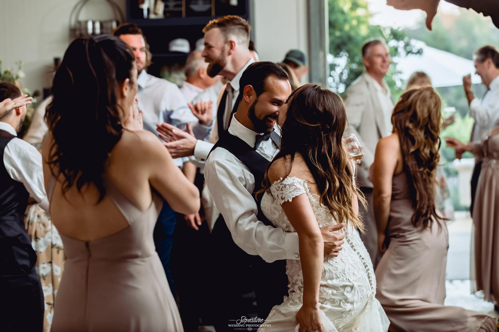 Bride and groom dancing at reception with family