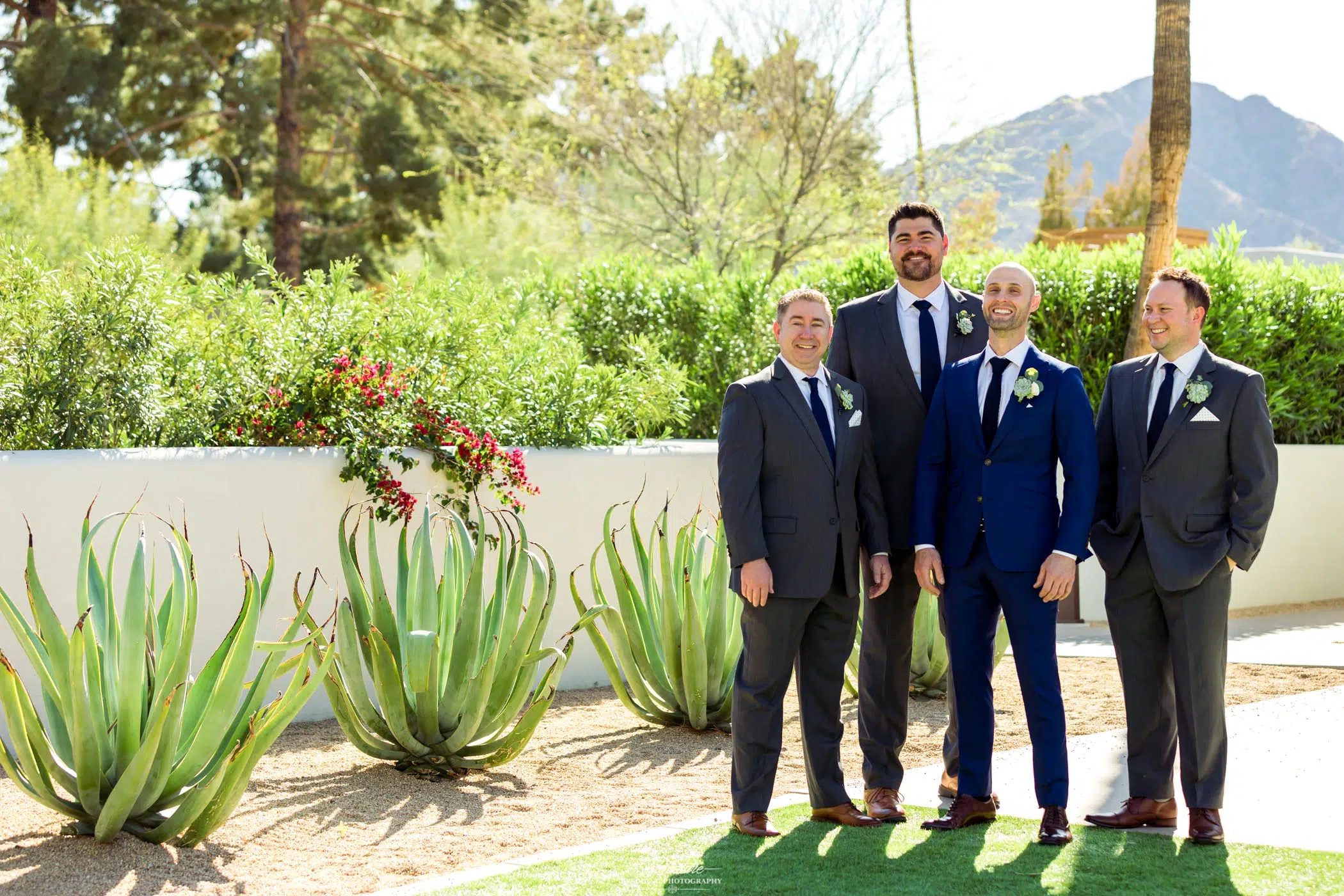Groom with groomsmen smiling outside