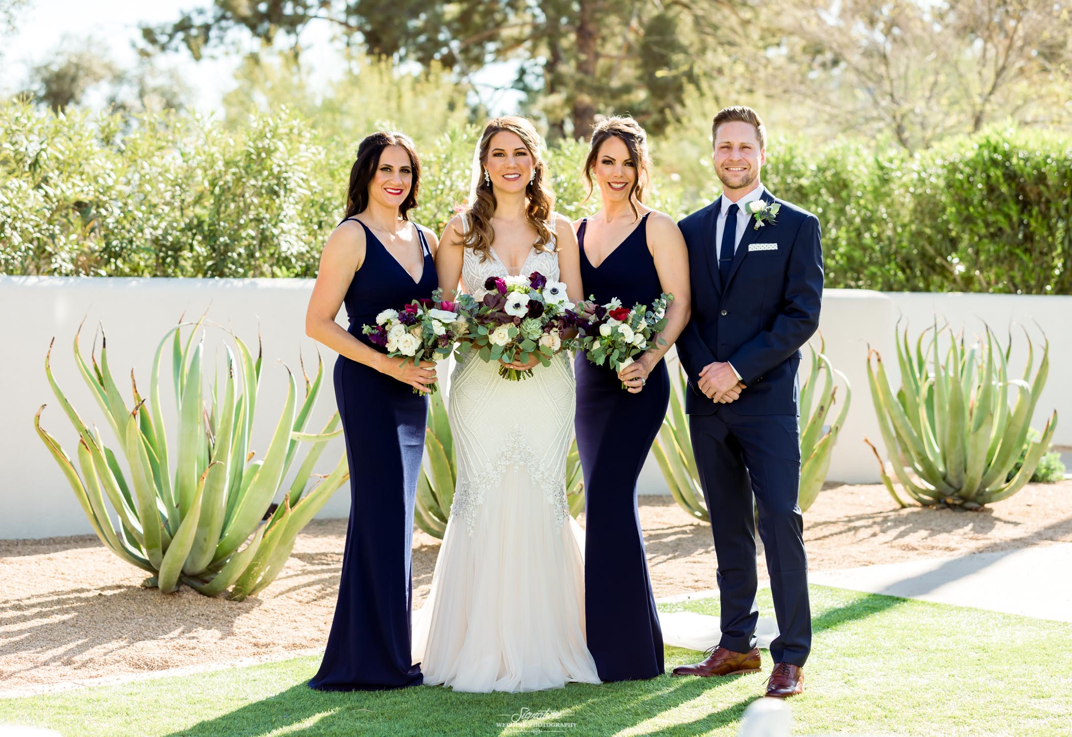 Bride with bridal party smiling outside