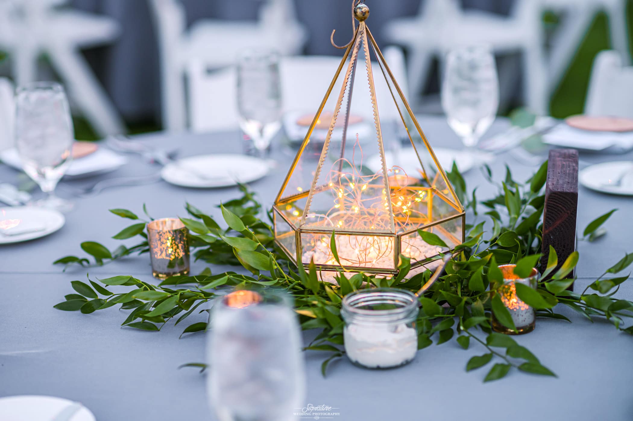 Gold lantern with lights and greenery center pieces
