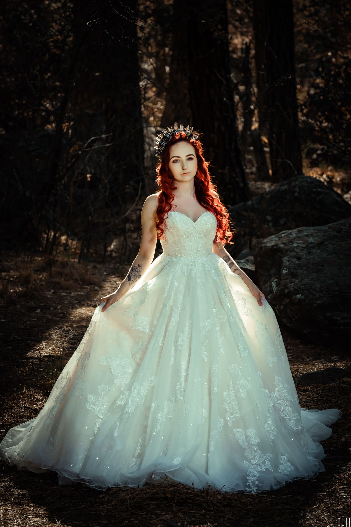 Bride holding dress in forest