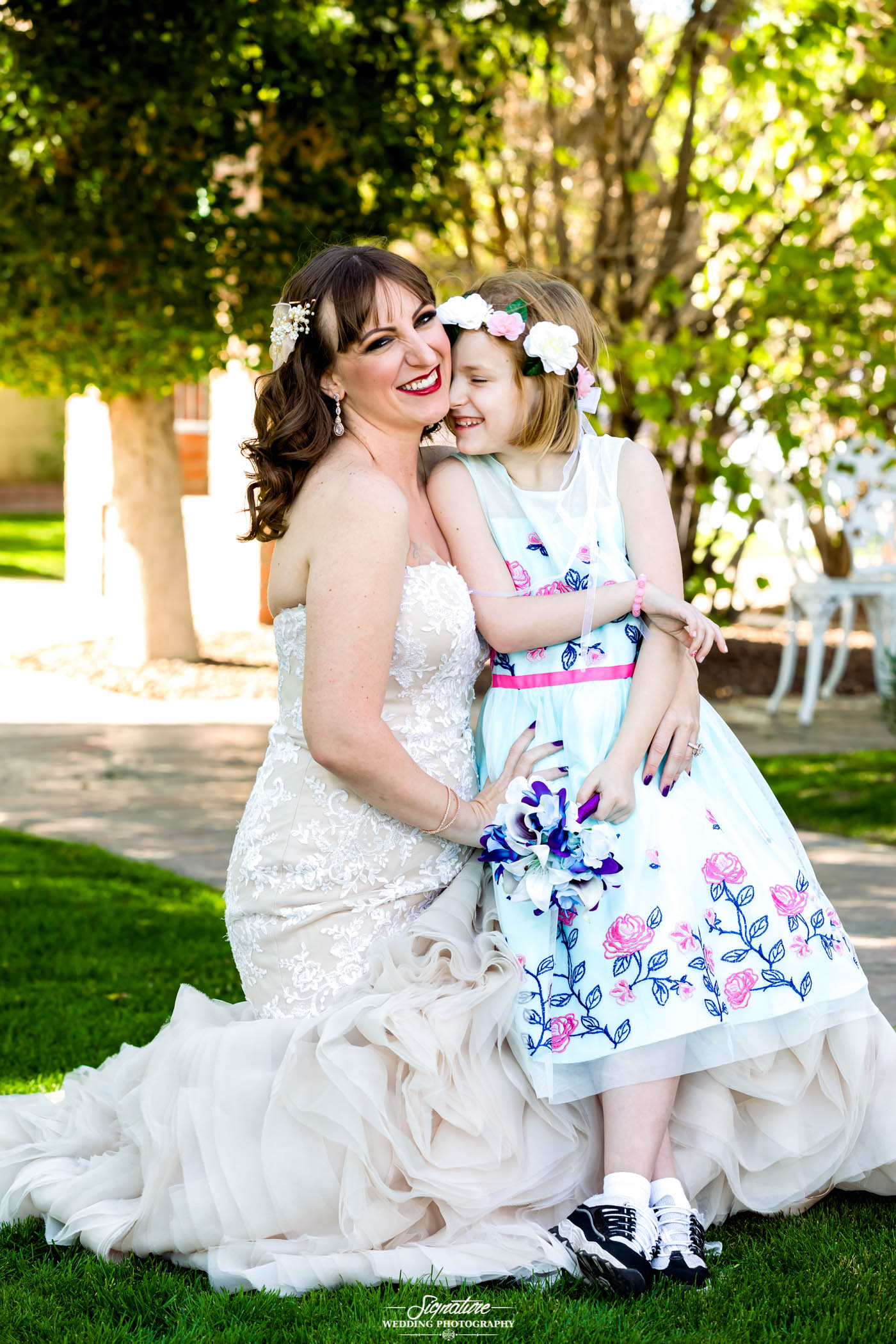 Bride with daughter smiling outside