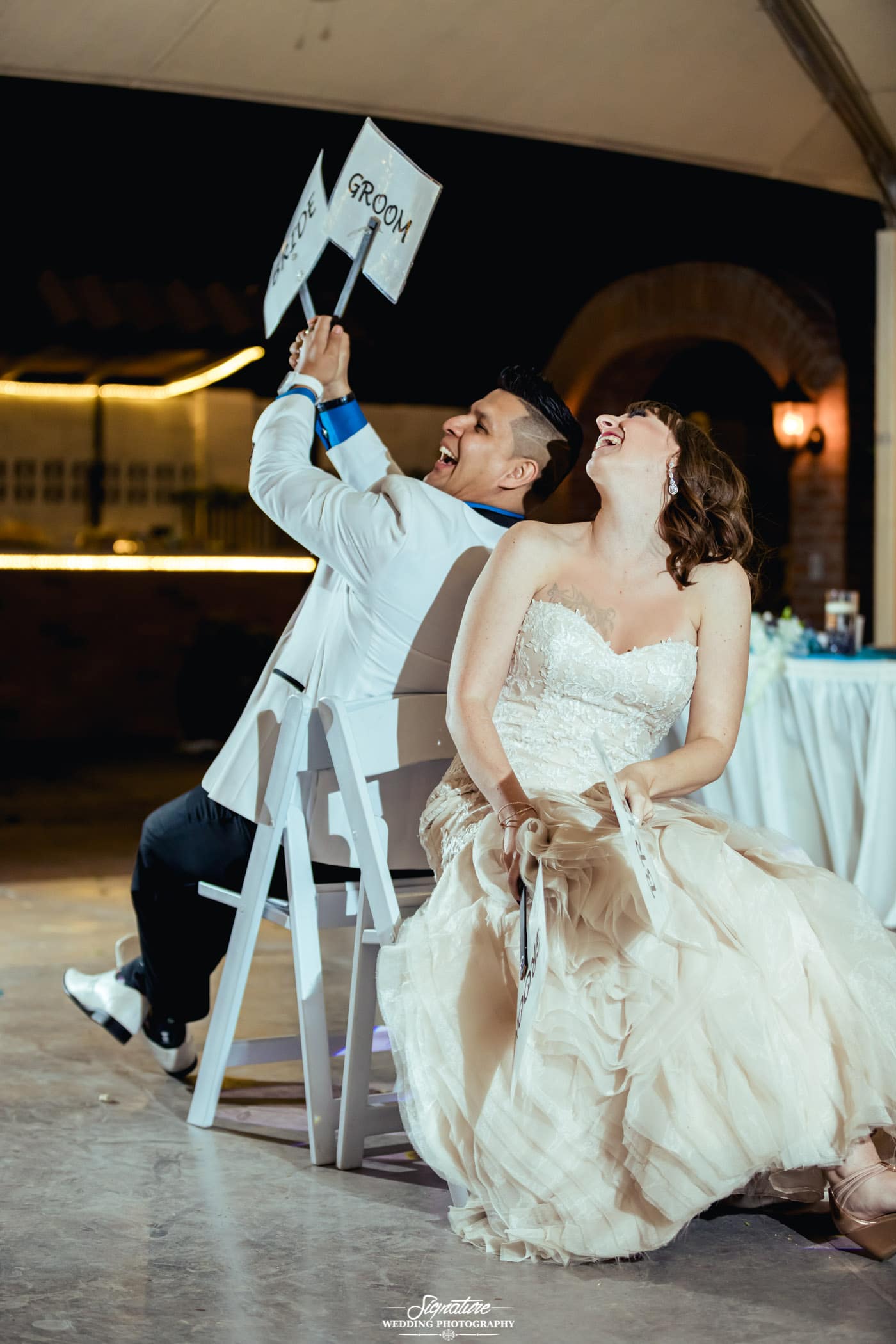 Bride and groom back to back on chairs for wedding game