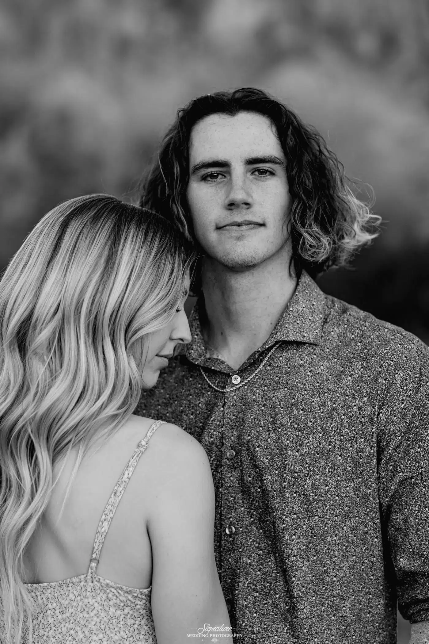 Couple with girl leaning into guy's chest black and white