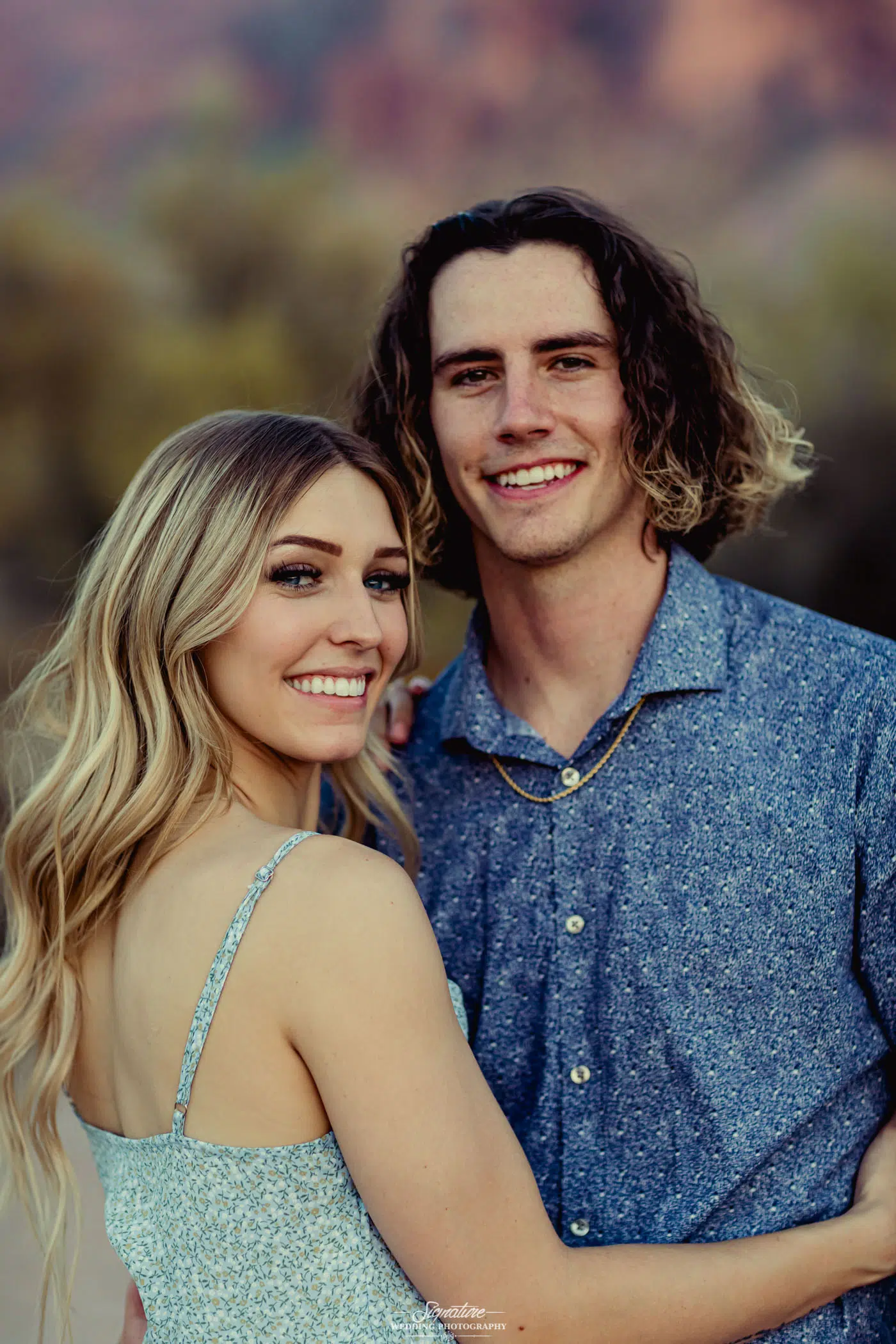 Couple hugging and smiling at camera