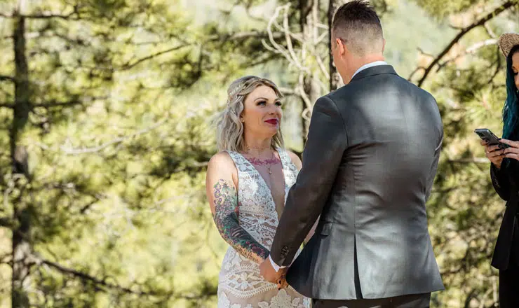 Bride and groom holding hands in forest
