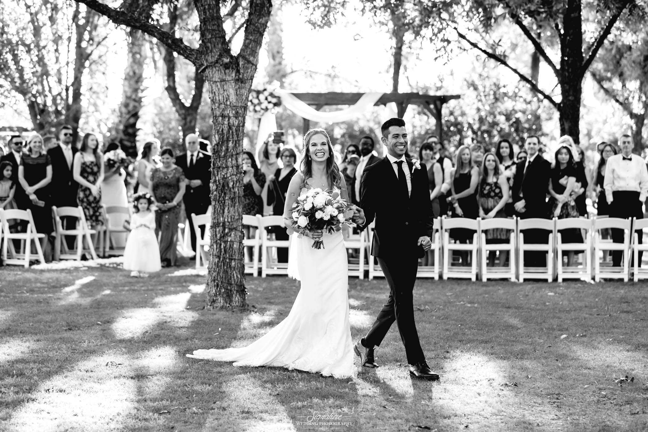 Bride and groom walking down isle black and white