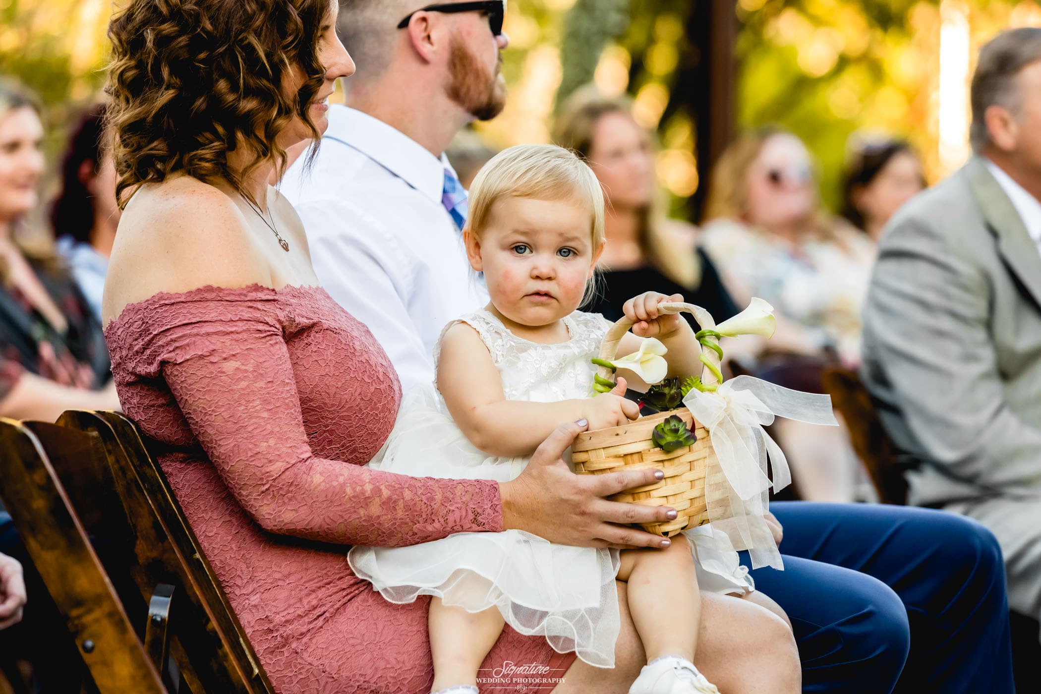Wedding guest with flower girl in lap