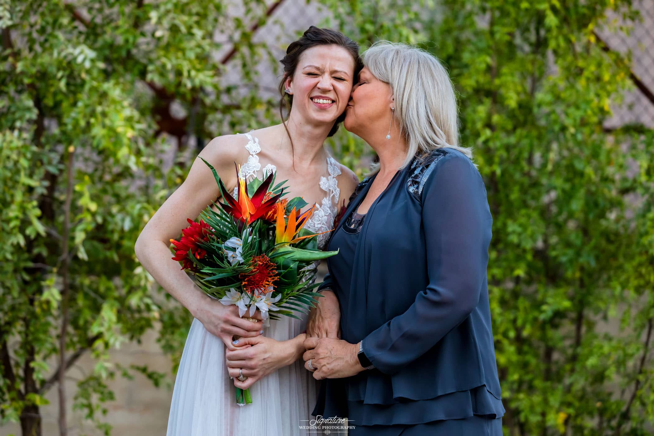 Matriarch kissing bride on cheek