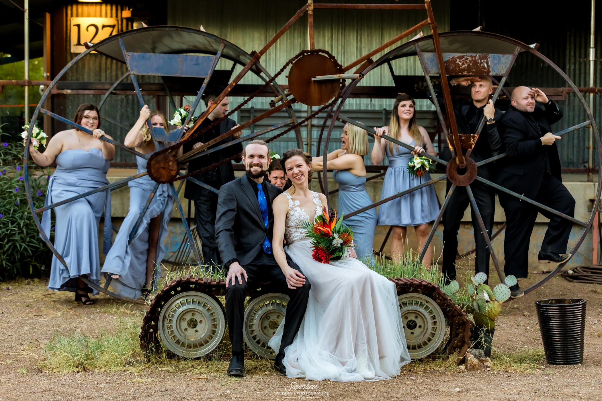 Bride, groom, and wedding party with giant bike statue