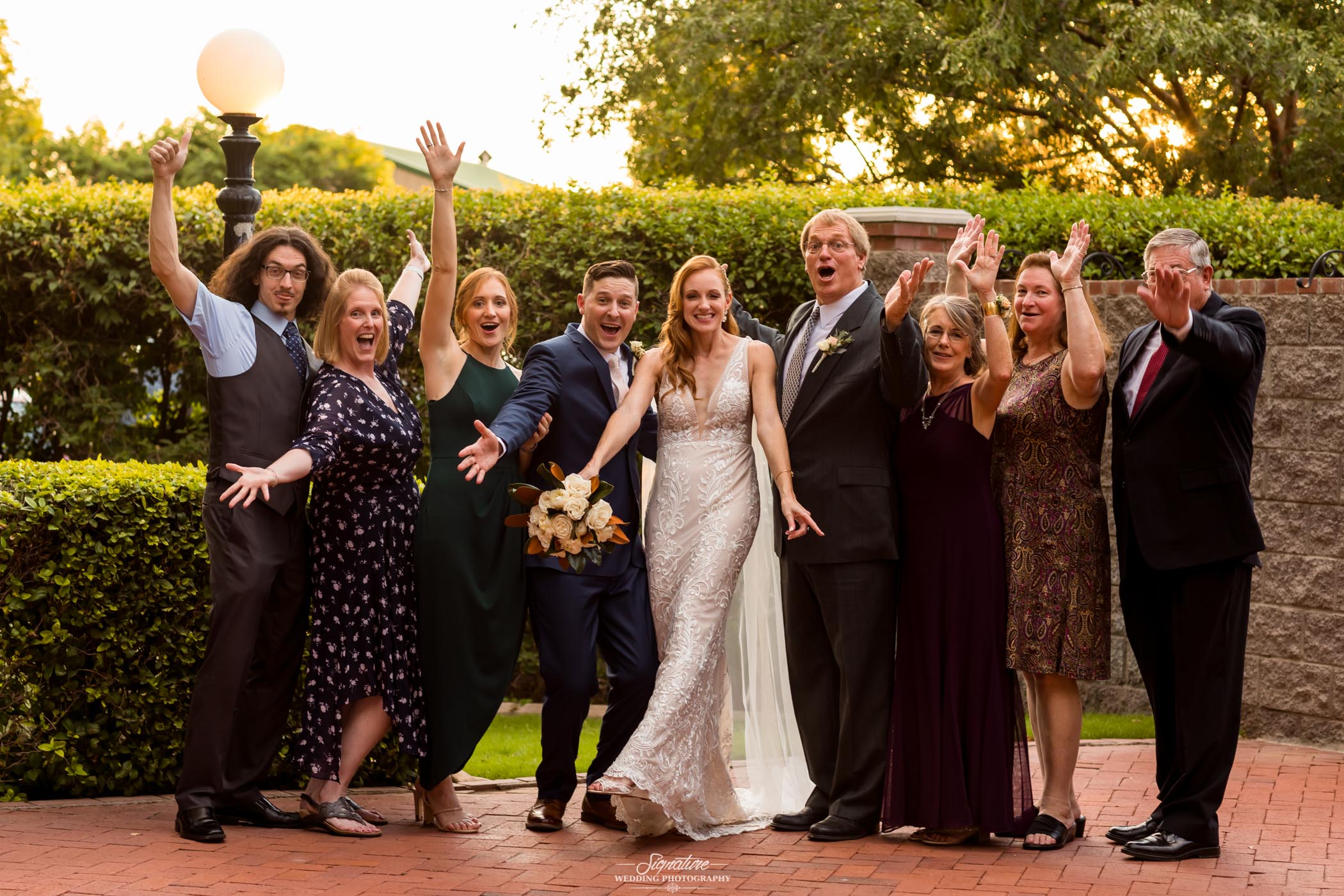Bride and groom family picture arms up