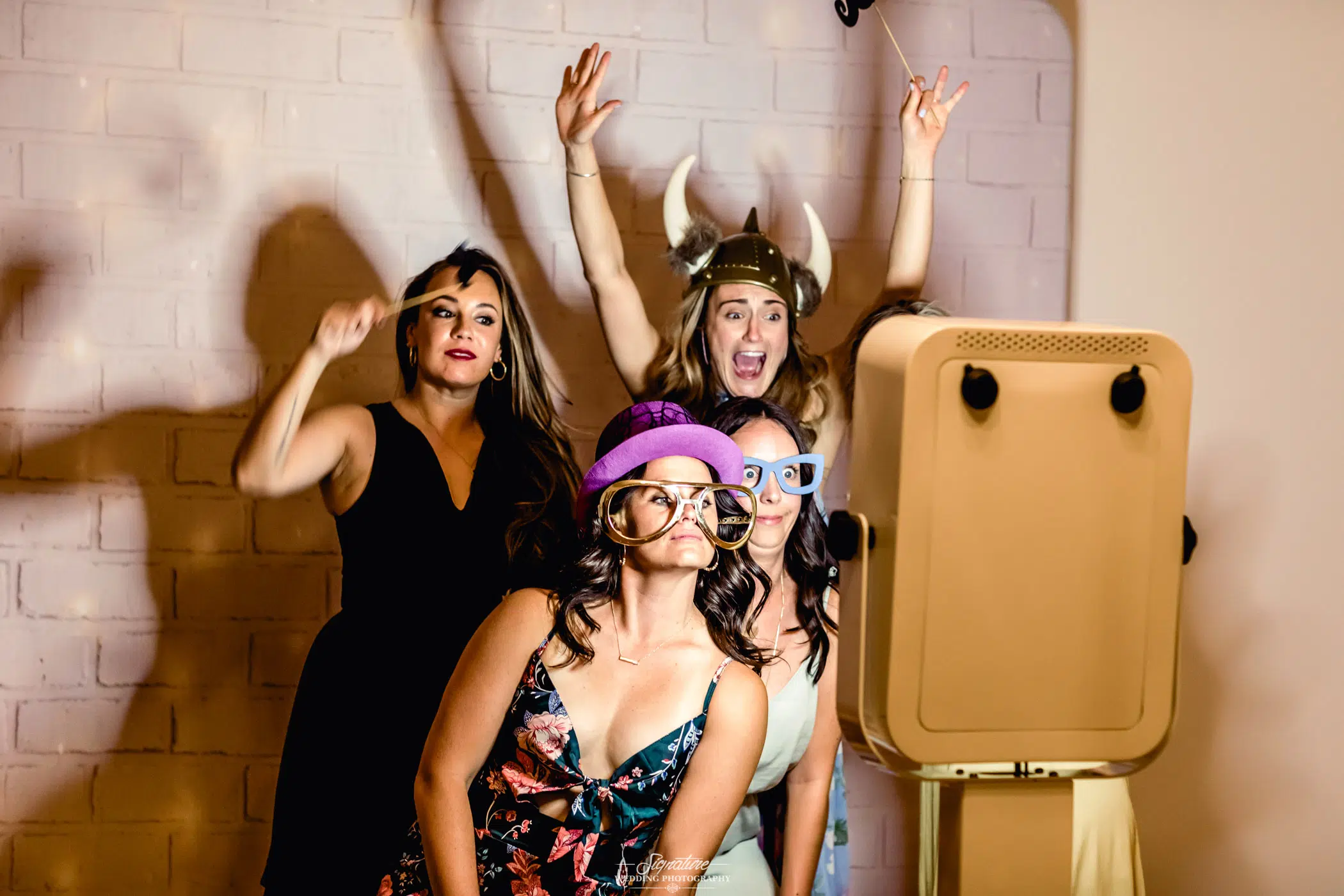 Wedding guests using props for photobooth