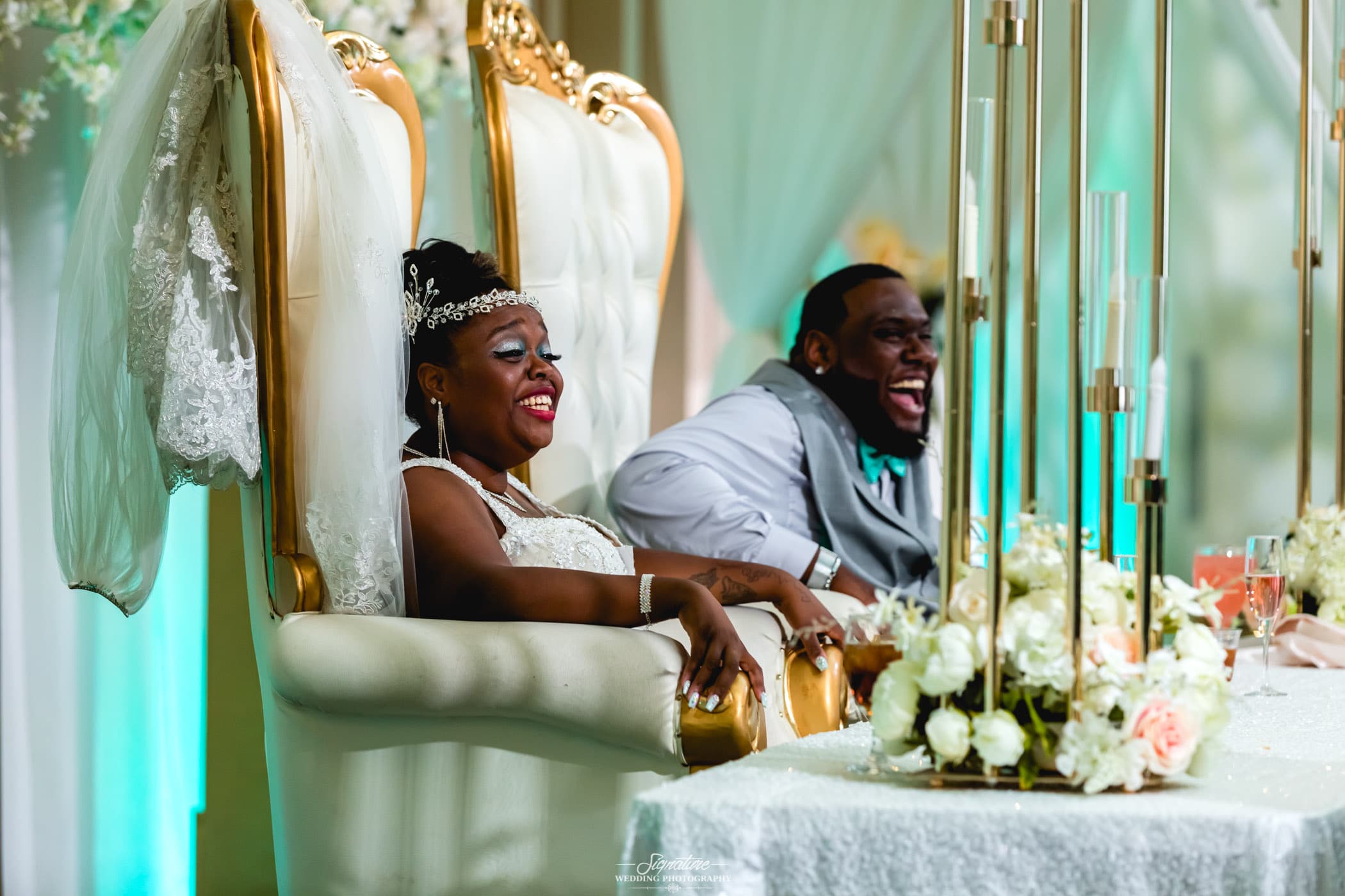 Bride and groom laughing at sweetheart table