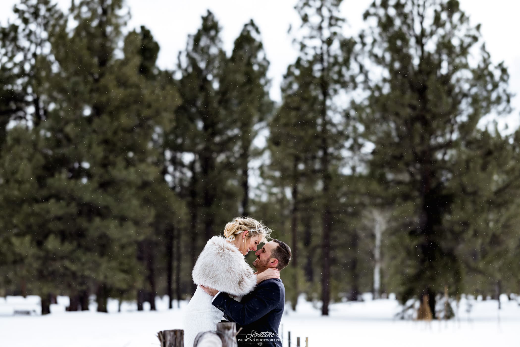 Bride and groom nose to nose smiling in snow
