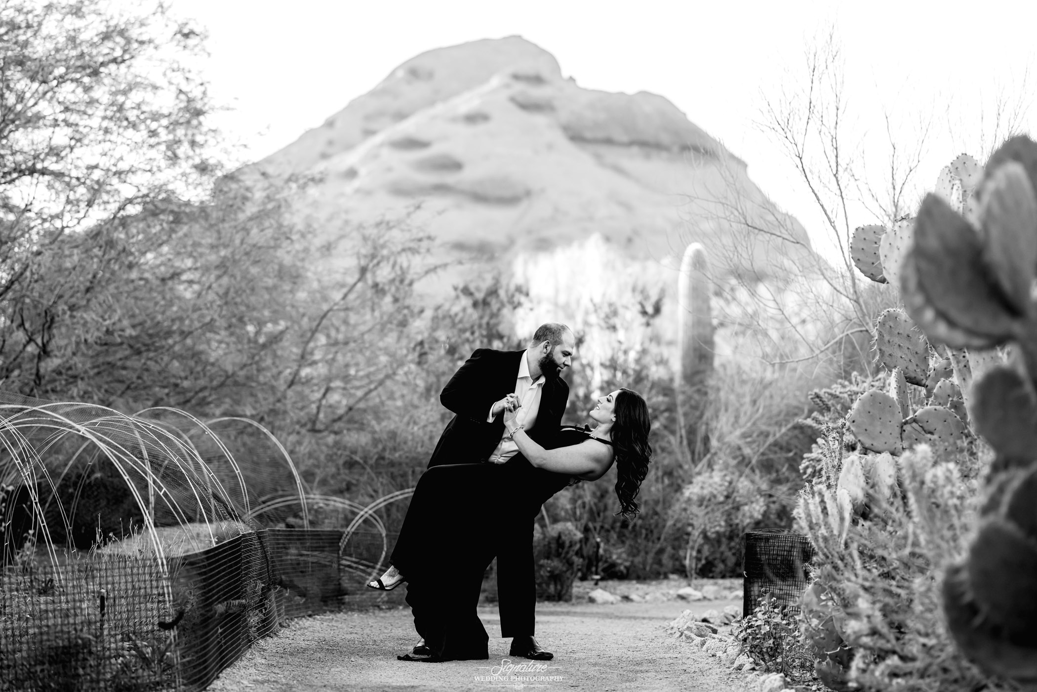 Man dipping woman in desert black and white