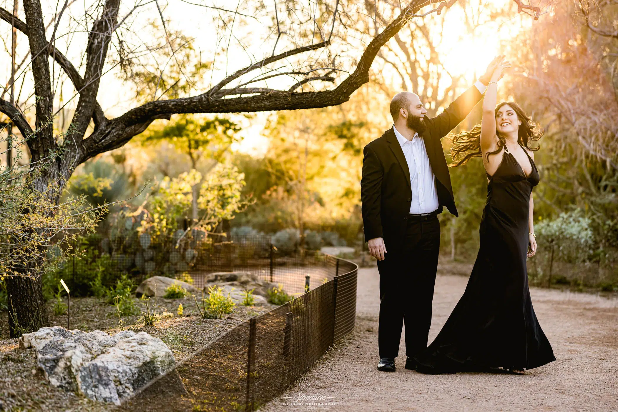 Man spinning woman at sunset in desert