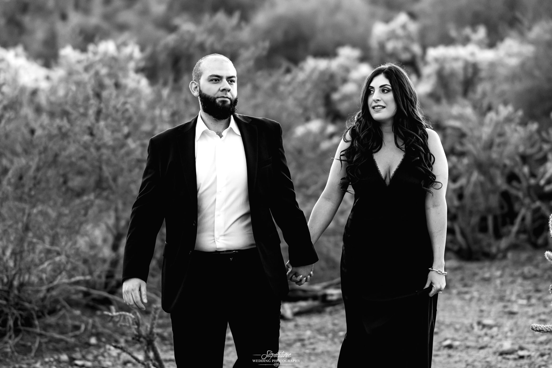 Couple holding hands in desert black and white