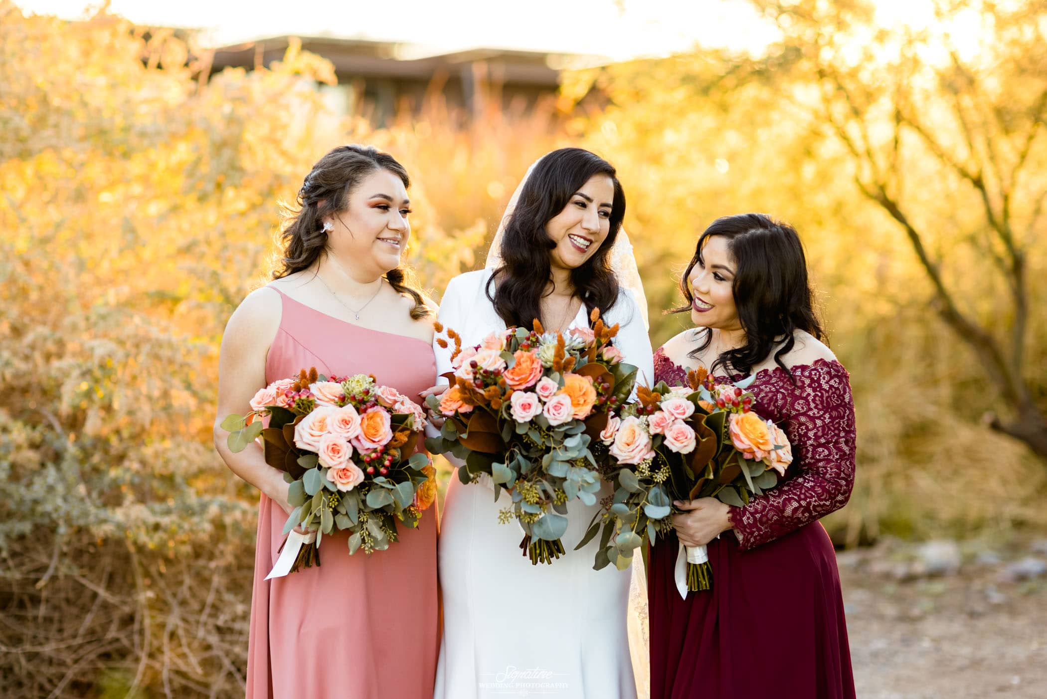 Bride and bridesmaids smiling holding bouquets
