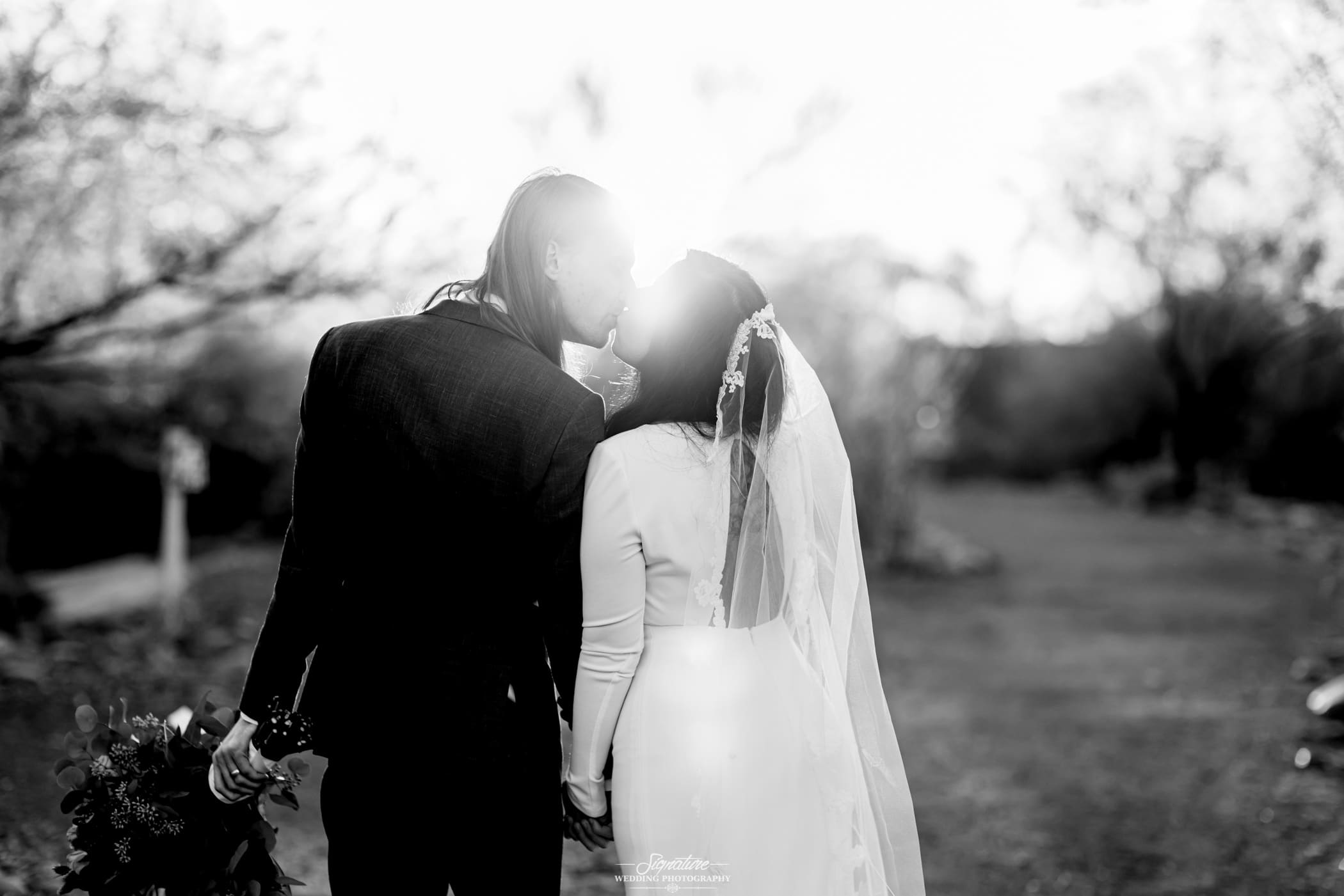 Behind shot of bride and groom kissing black and white