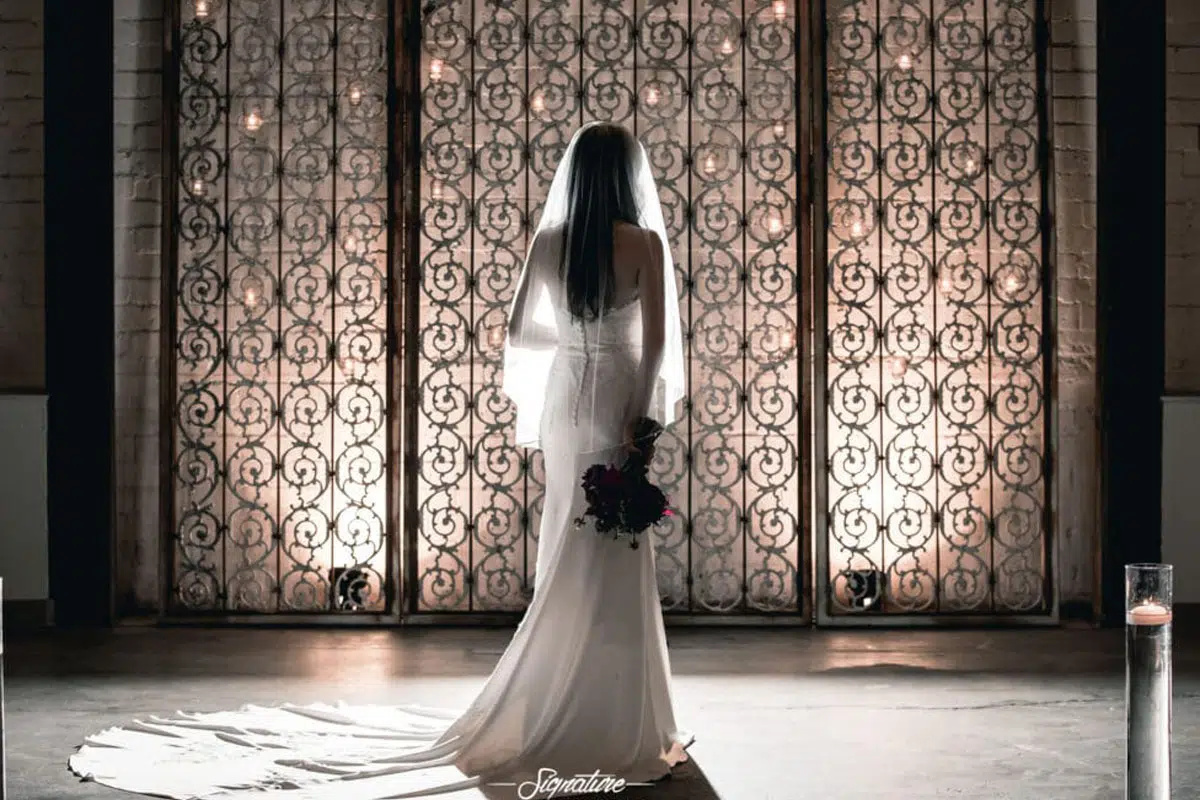 Behind shot of bride with bouquet in front of iron gating