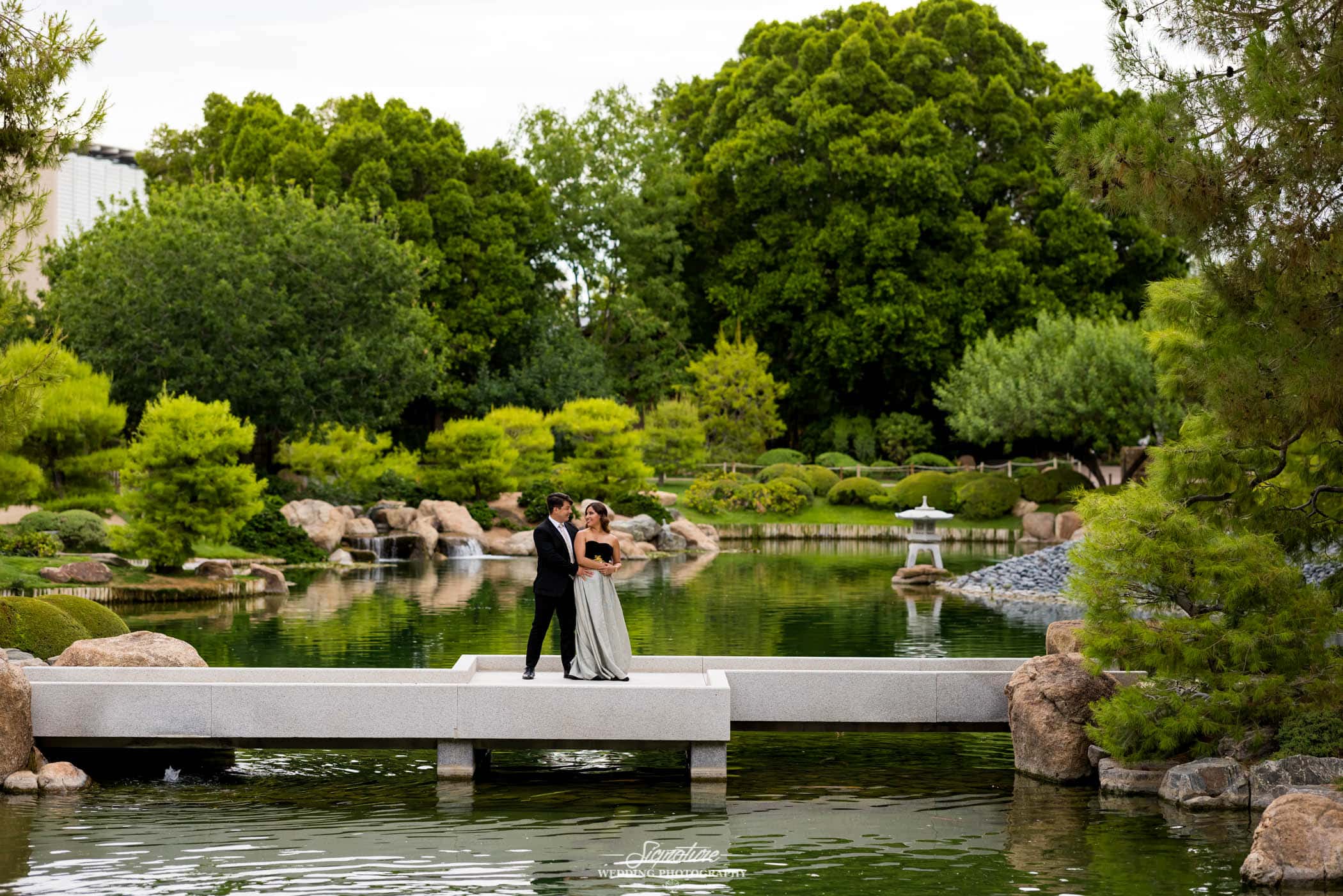 Couple standing on bridge in botanical garden