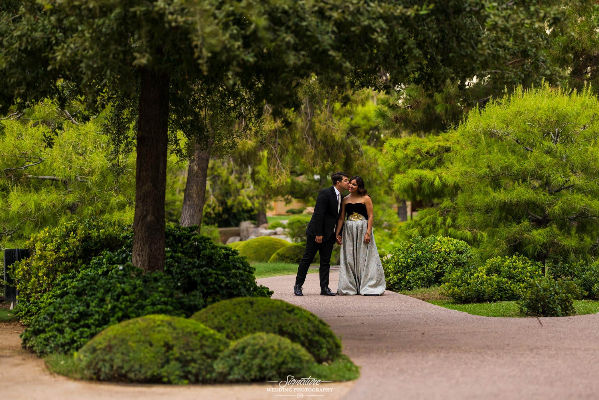 Man kissing woman on cheek in botanical garden