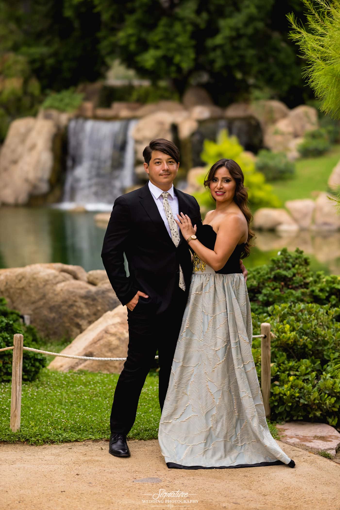 Couple smiling in front of waterfall