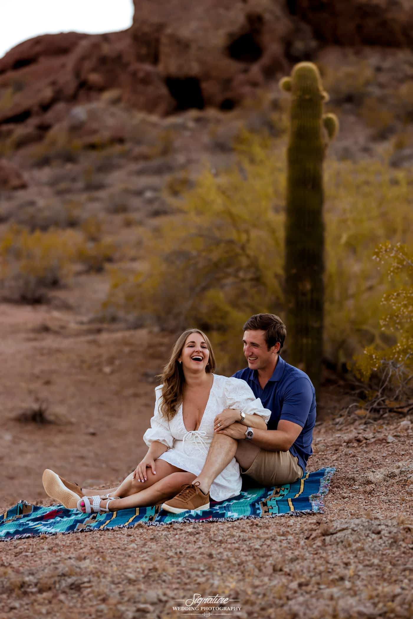 Couple sitting together on blanket in desert