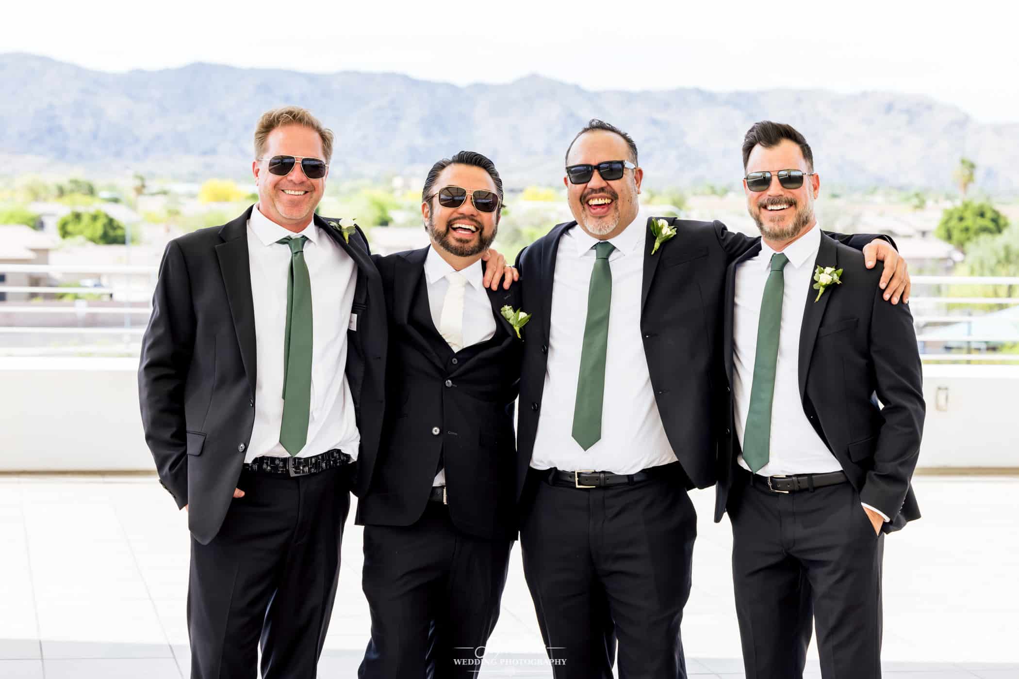 Groom smiling with groomsmen in sunglasses